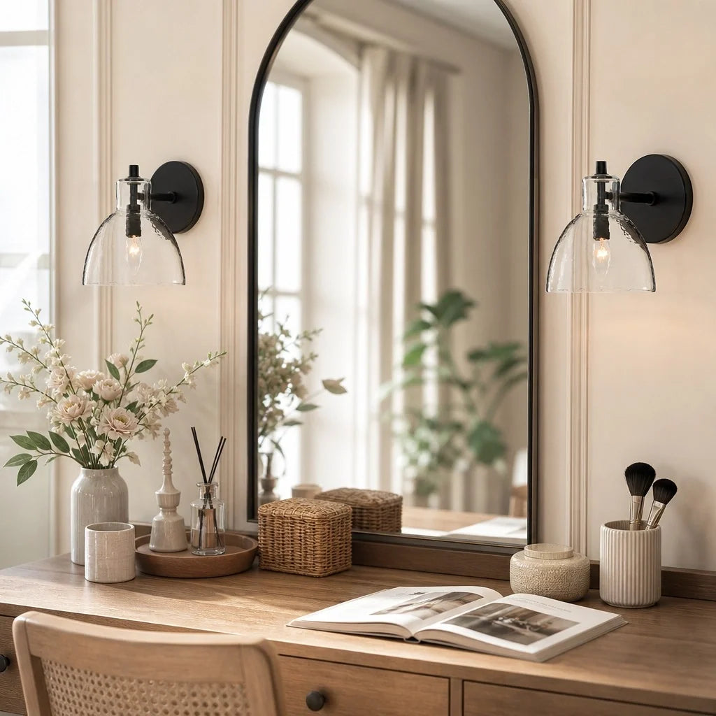 Pair of black hammered glass wall sconces flanking an arched mirror above a dressing table