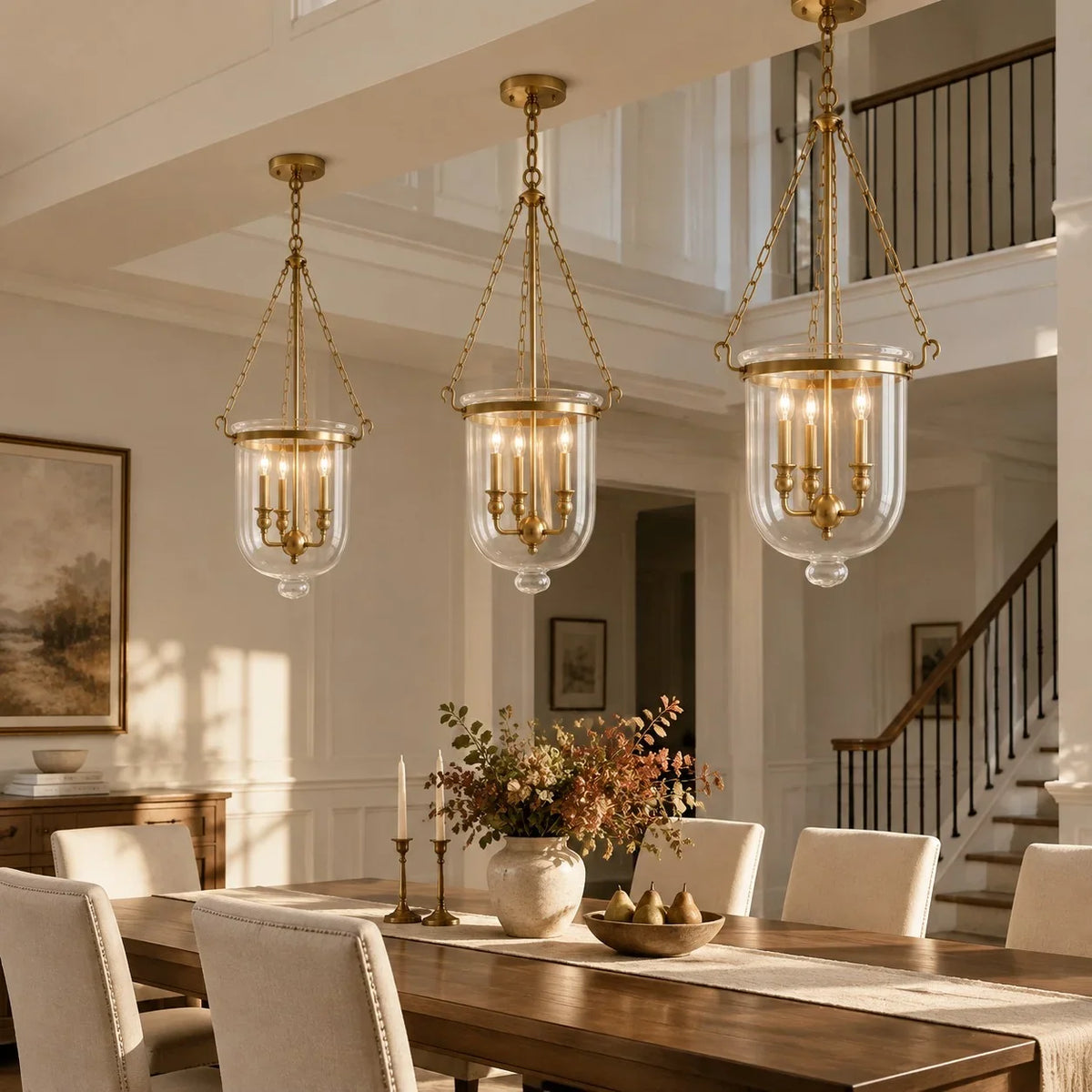 Three brass bell jar pendants over a farmhouse dining table