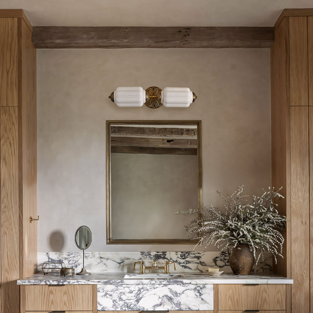 Raggiera Deco vanity light with white glass and brass plate above a mirror in an oak and marble bathroom