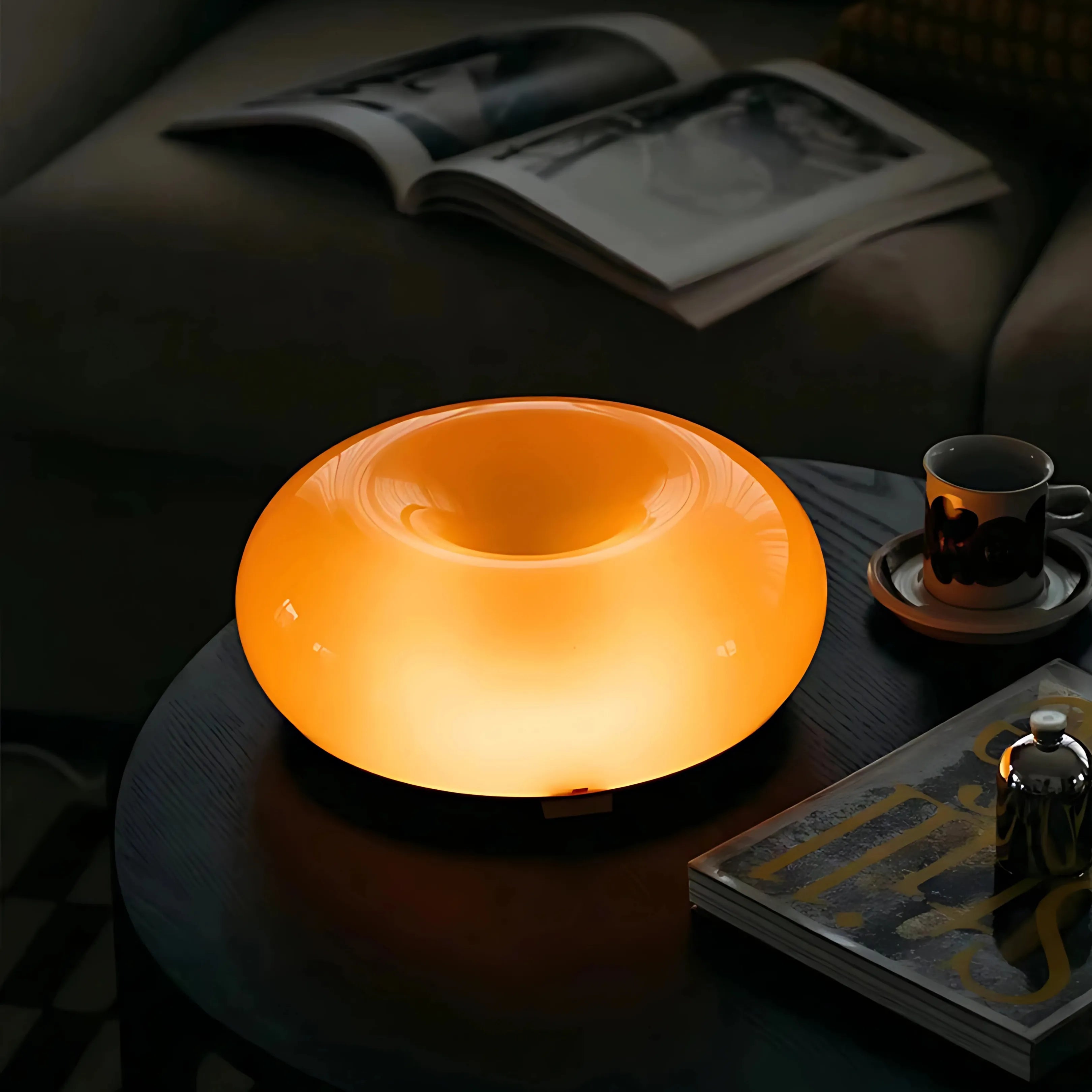 Sole Ambrato amber donut lamp glowing warm in the evening