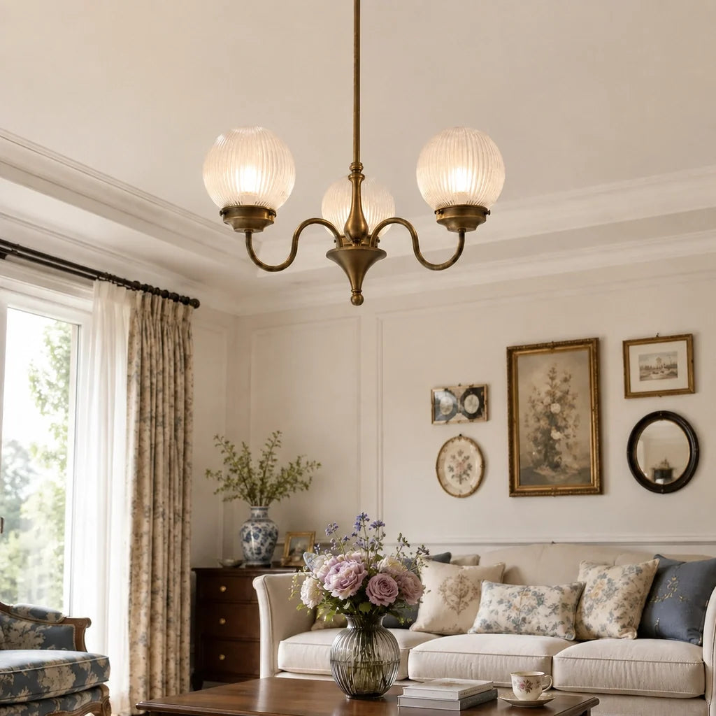 Antique brass globe chandelier in a living room with floral wallpaper