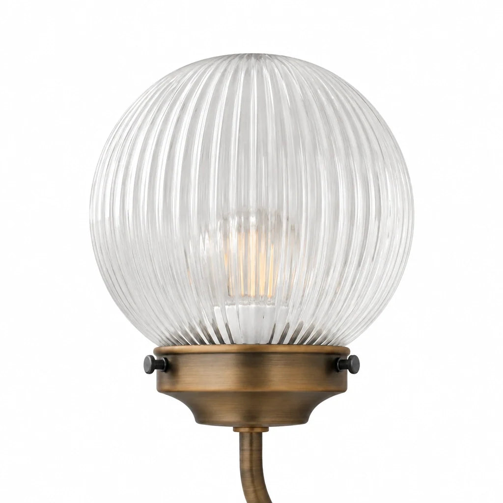 Ribbed glass globe and brass cup detail of the Lucciola Dorata chandelier