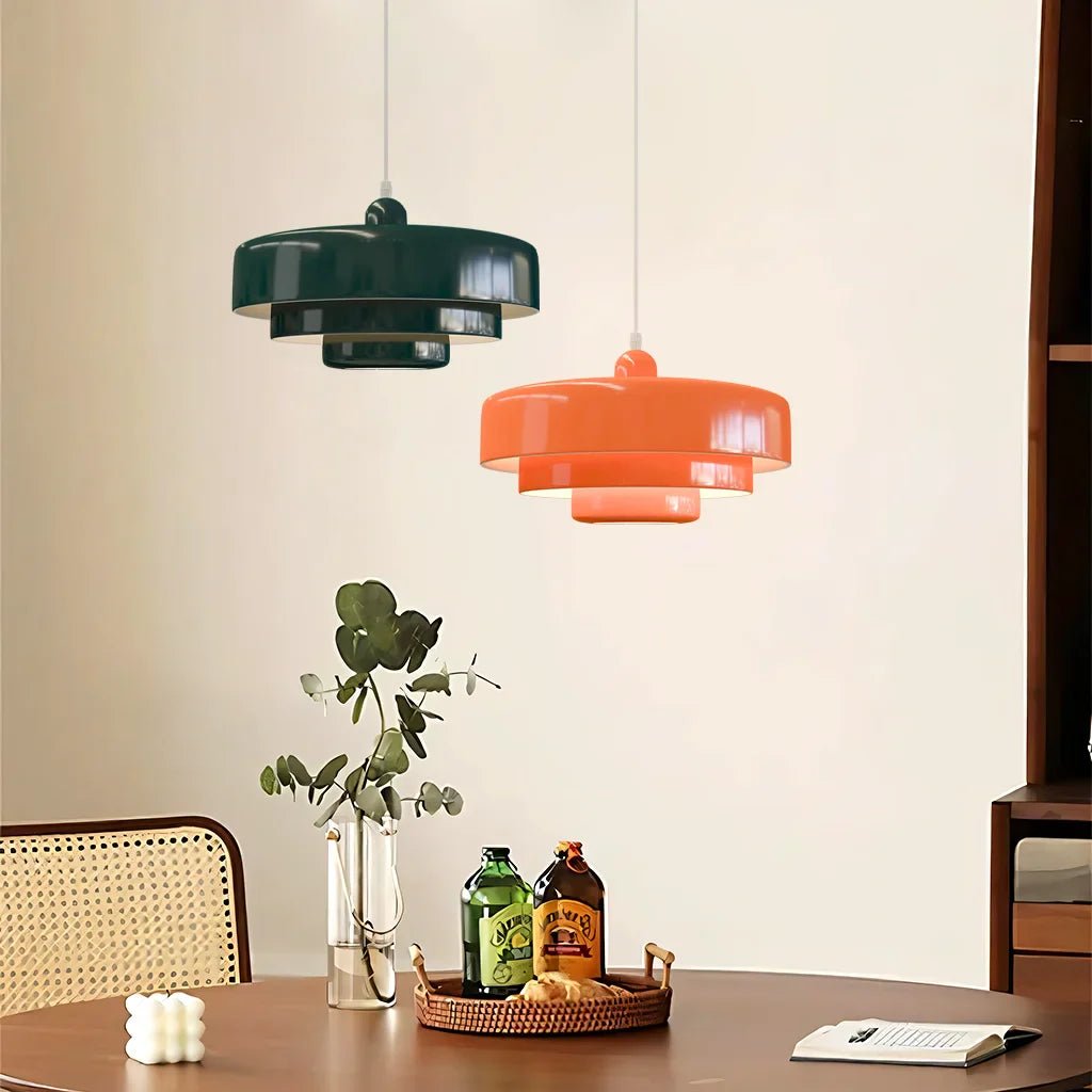 Green and orange macaron pendant lights over a wood dining table