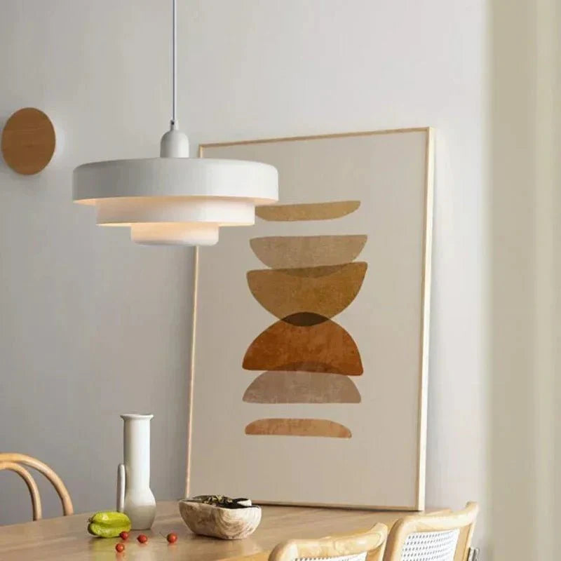 White macaron pendant light over a dining table with an art print