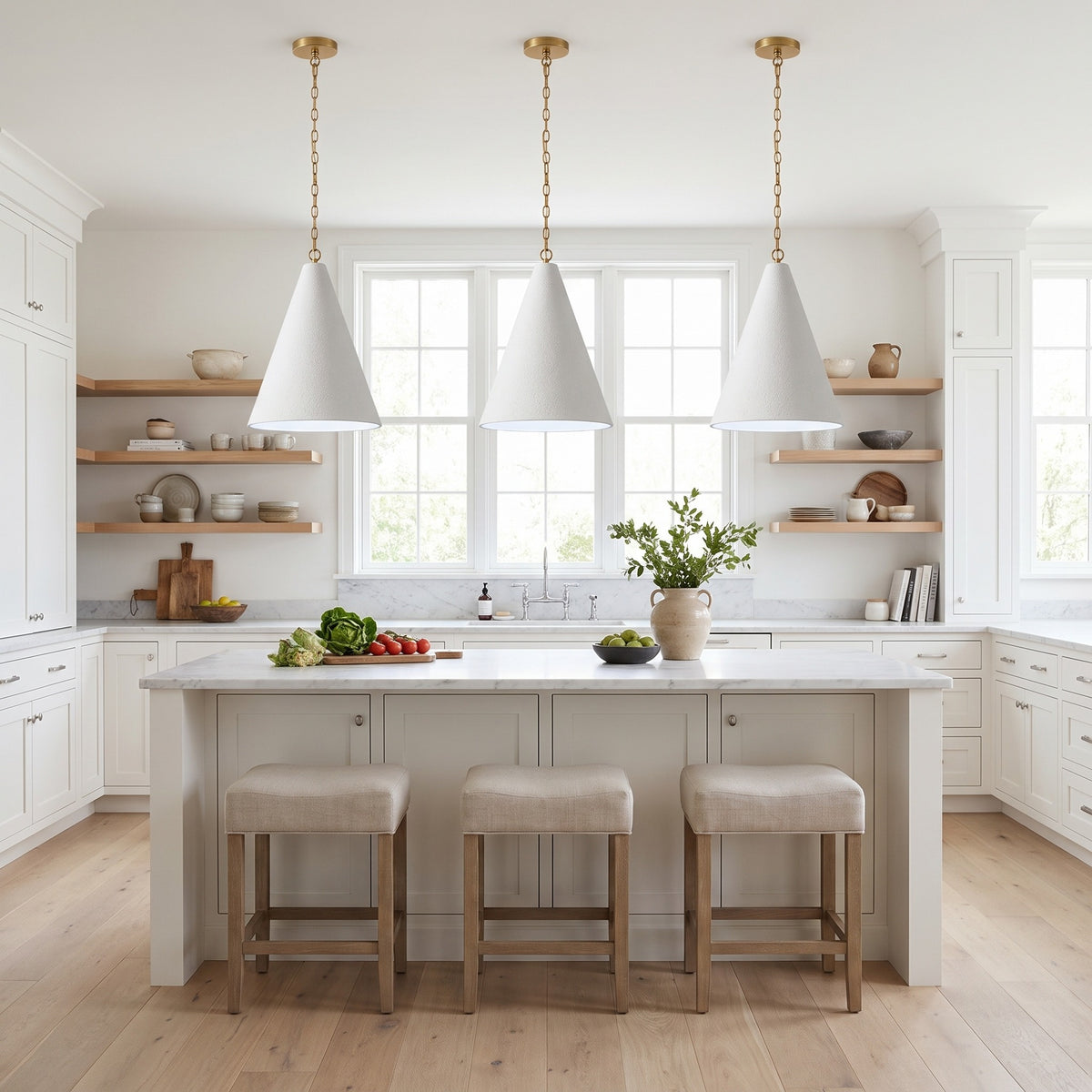Three all-white Calma Gessata plaster cone pendants over a marble kitchen island