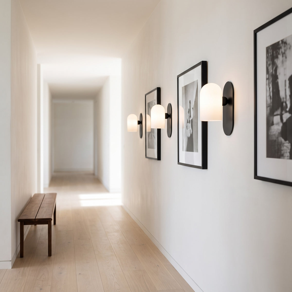 Capsula Opalina gunmetal wall sconces lining a bright gallery hallway