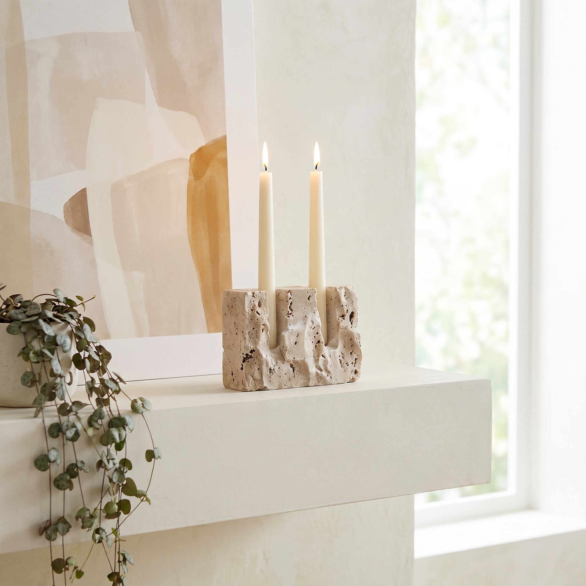 Raw travertine taper candle stand styled on a minimalist plaster mantel