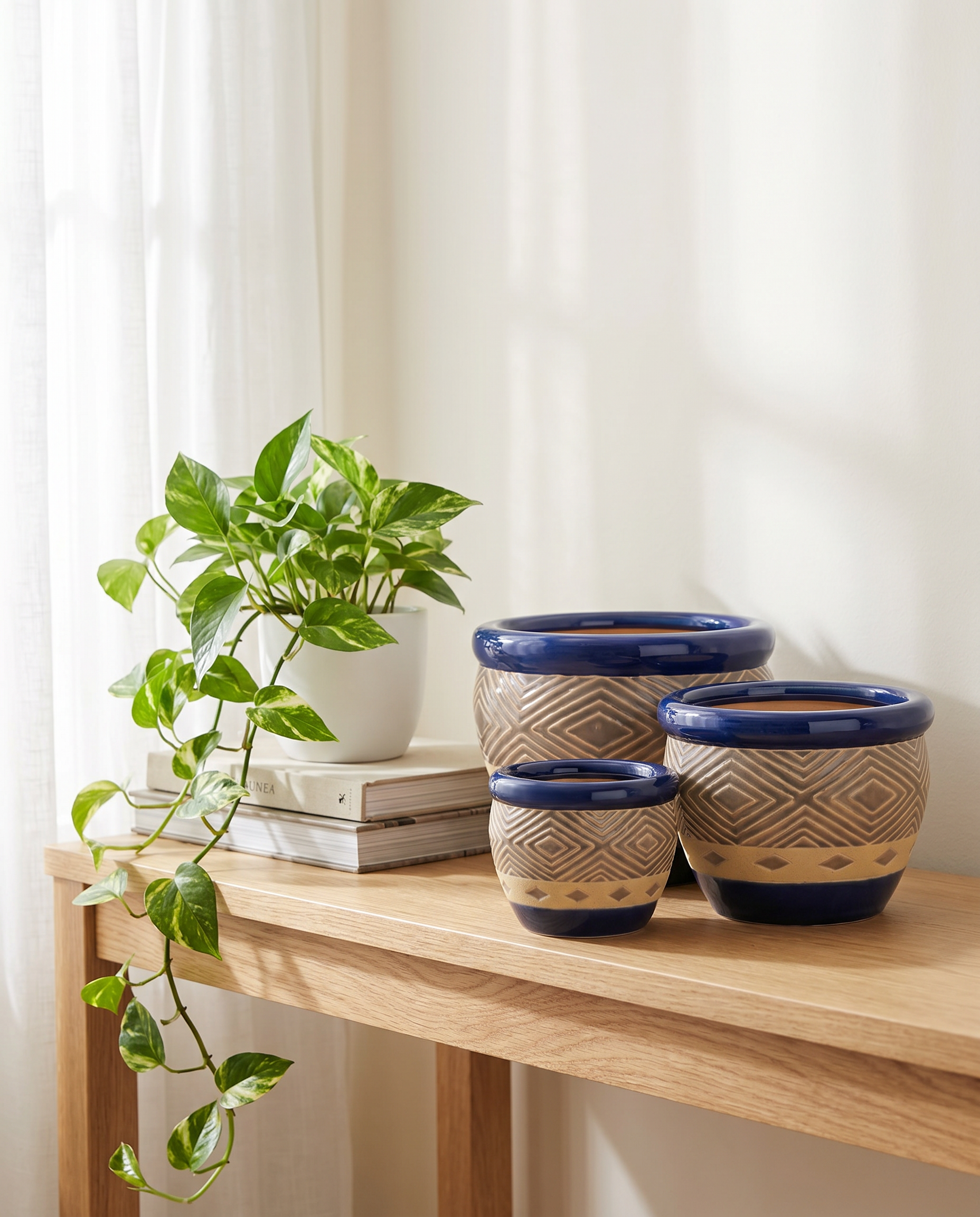 Cobalt blue ceramic planter set displayed on a console in a bright modern living room