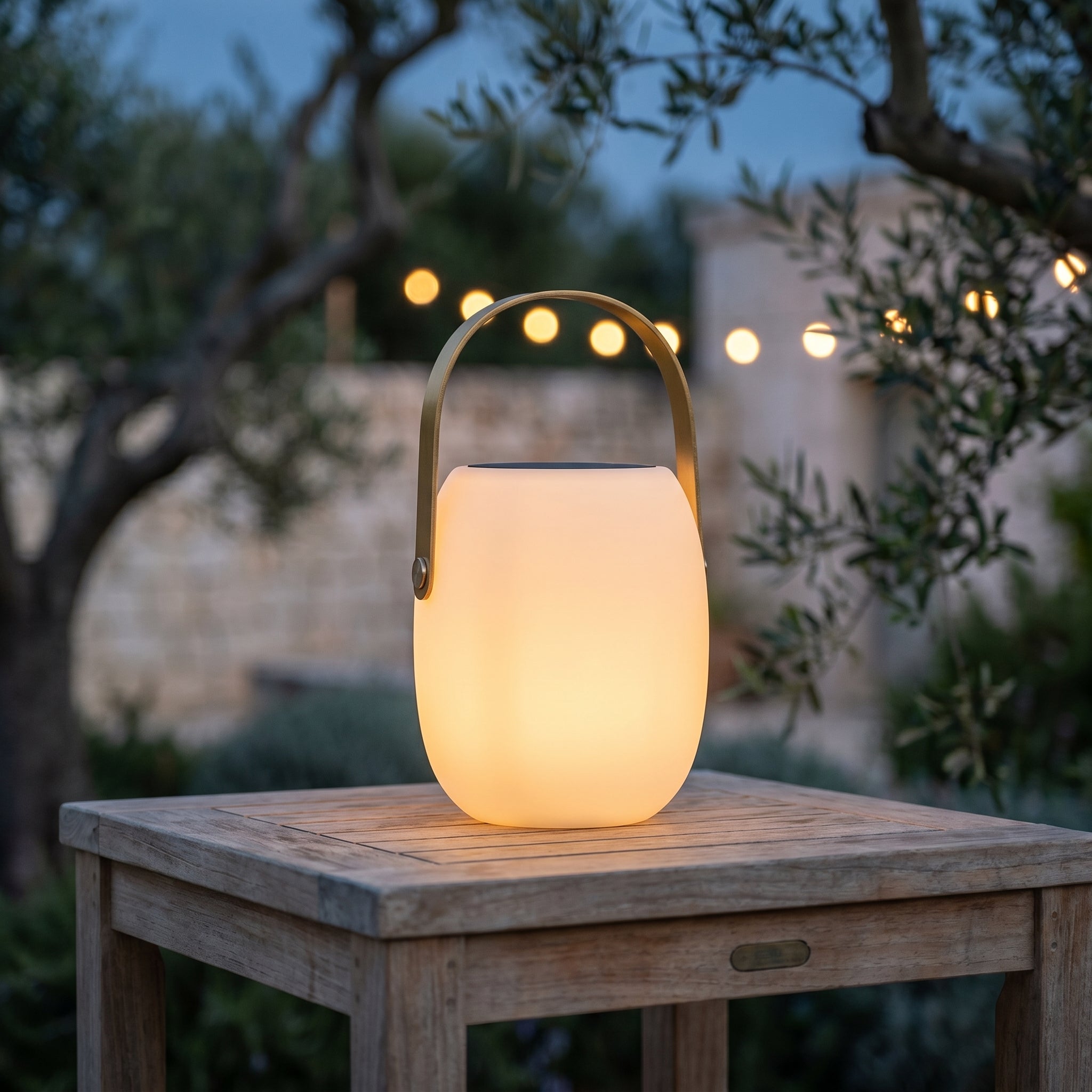 Lucciola Costiera portable outdoor lantern glowing warm on an Italian terrace at dusk