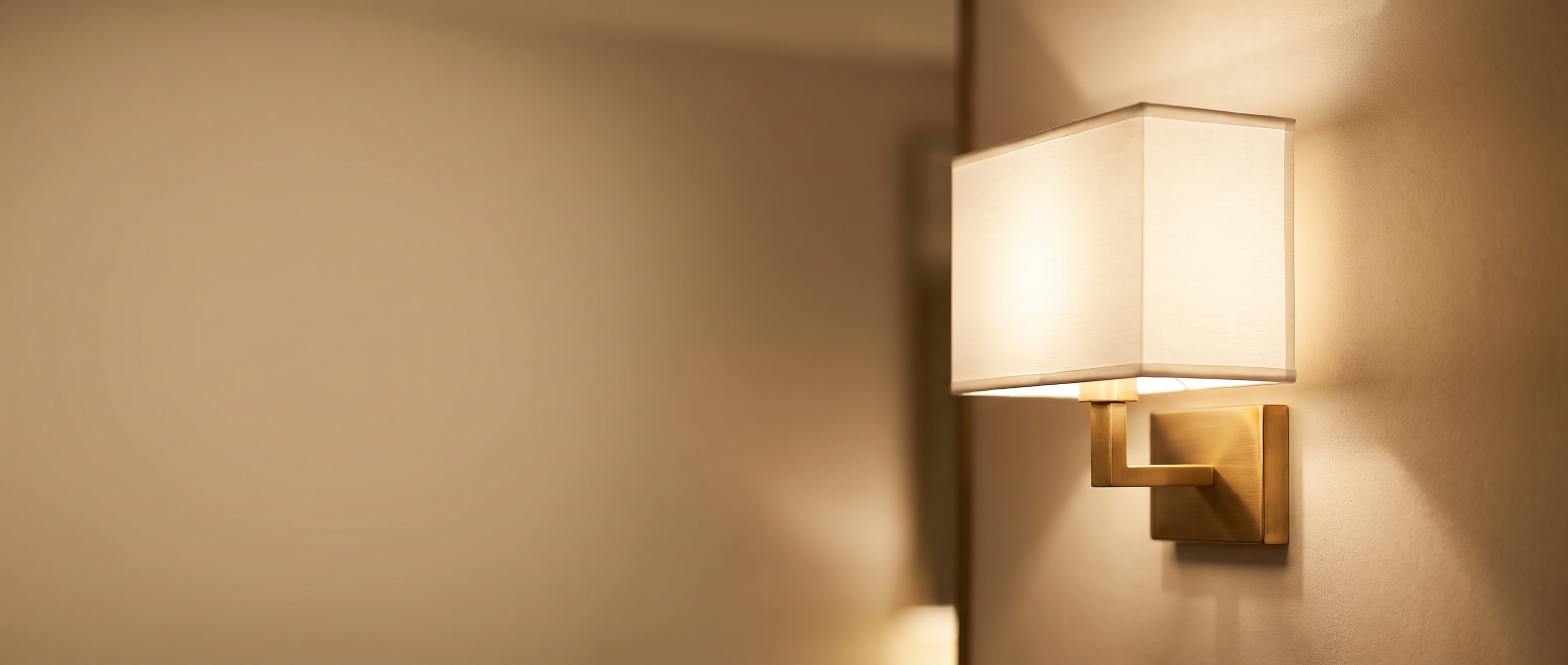 Cuboid fabric wall sconce on a softly textured wall, warm glow — Zanoro Casa