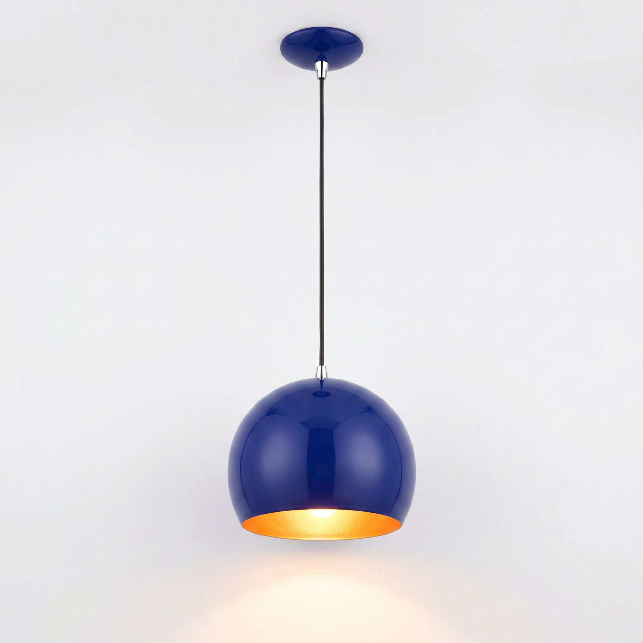 Cobalt blue globe pendant light glowing warm, clean studio product shot