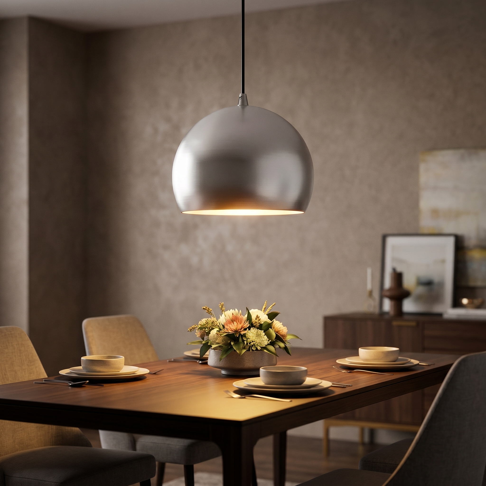 Brushed aluminum globe pendant light above a modern dining table