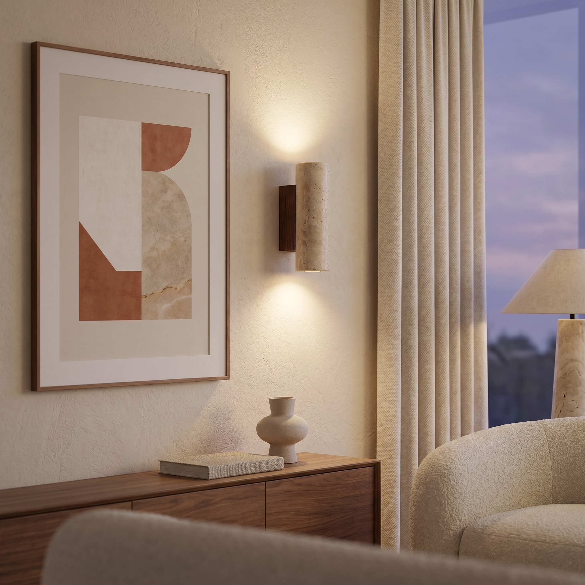 Travertine wall sconce glowing warm beside framed art in a modern living room
