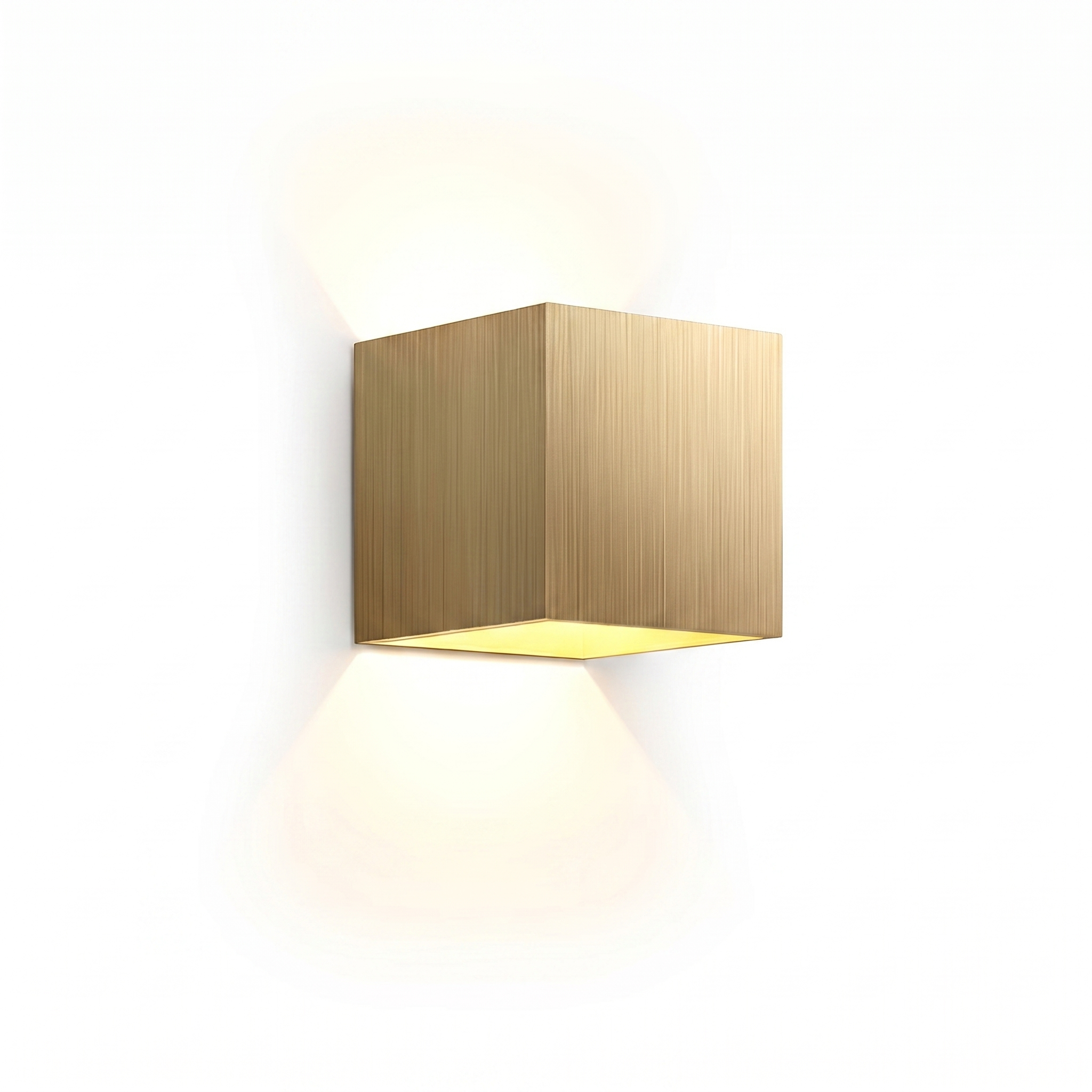 Cubo Luminoso gold cube up-down wall light with warm glow on a white background