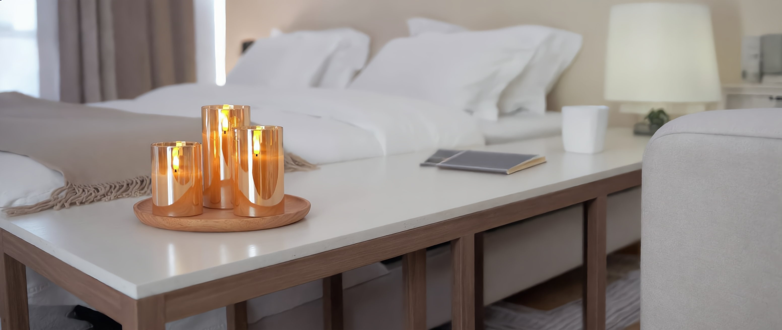 Fiamma Serena amber flameless candles glowing in a cozy bedroom (banner)