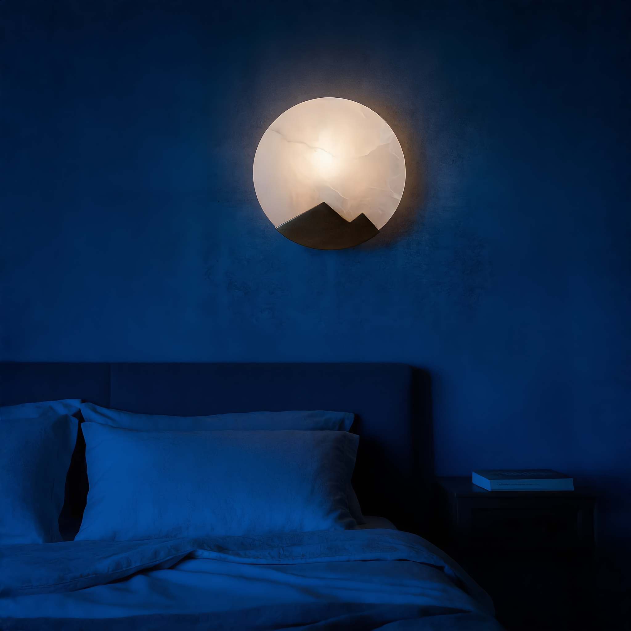 Luna d'Alabastro alabaster moon wall sconce glowing warm above a headboard in a blue-hour bedroom