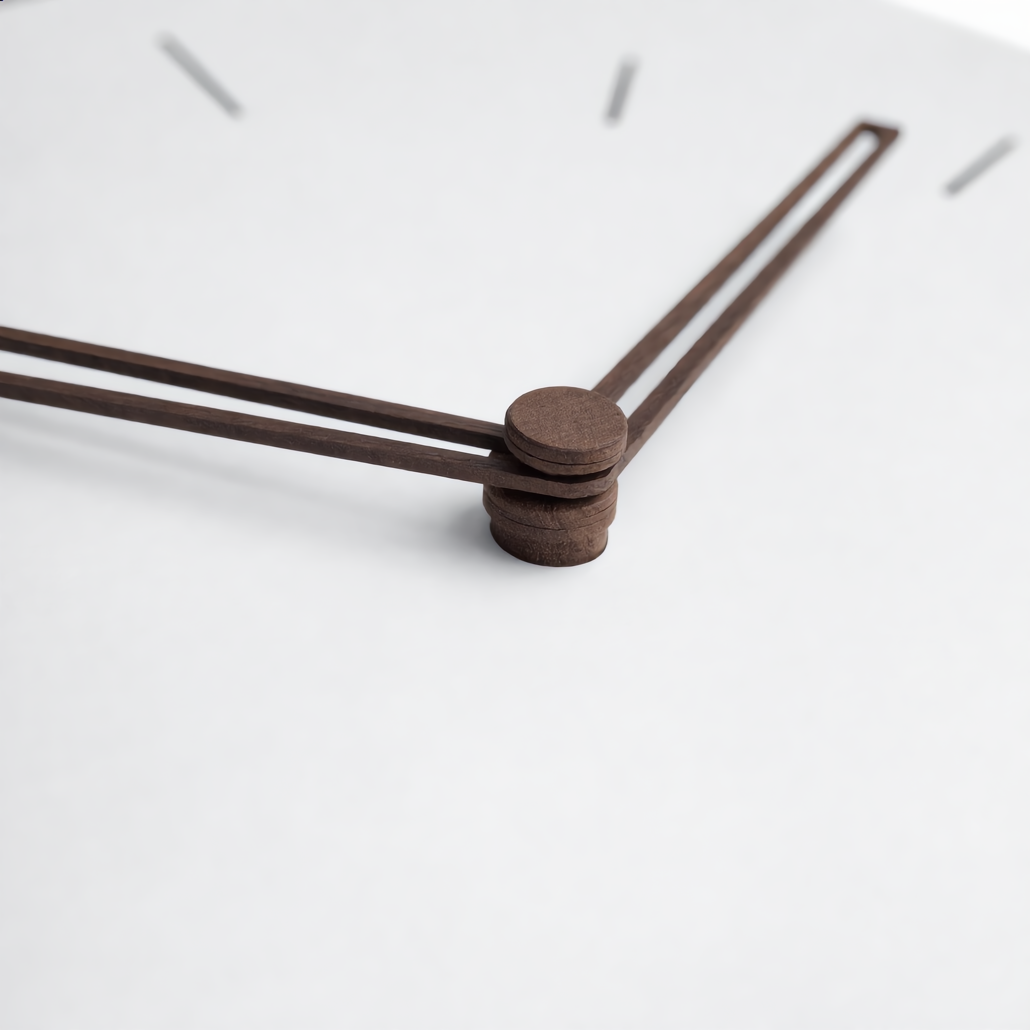 Macro detail of the walnut wood hands and matte white face of the Quadra clock
