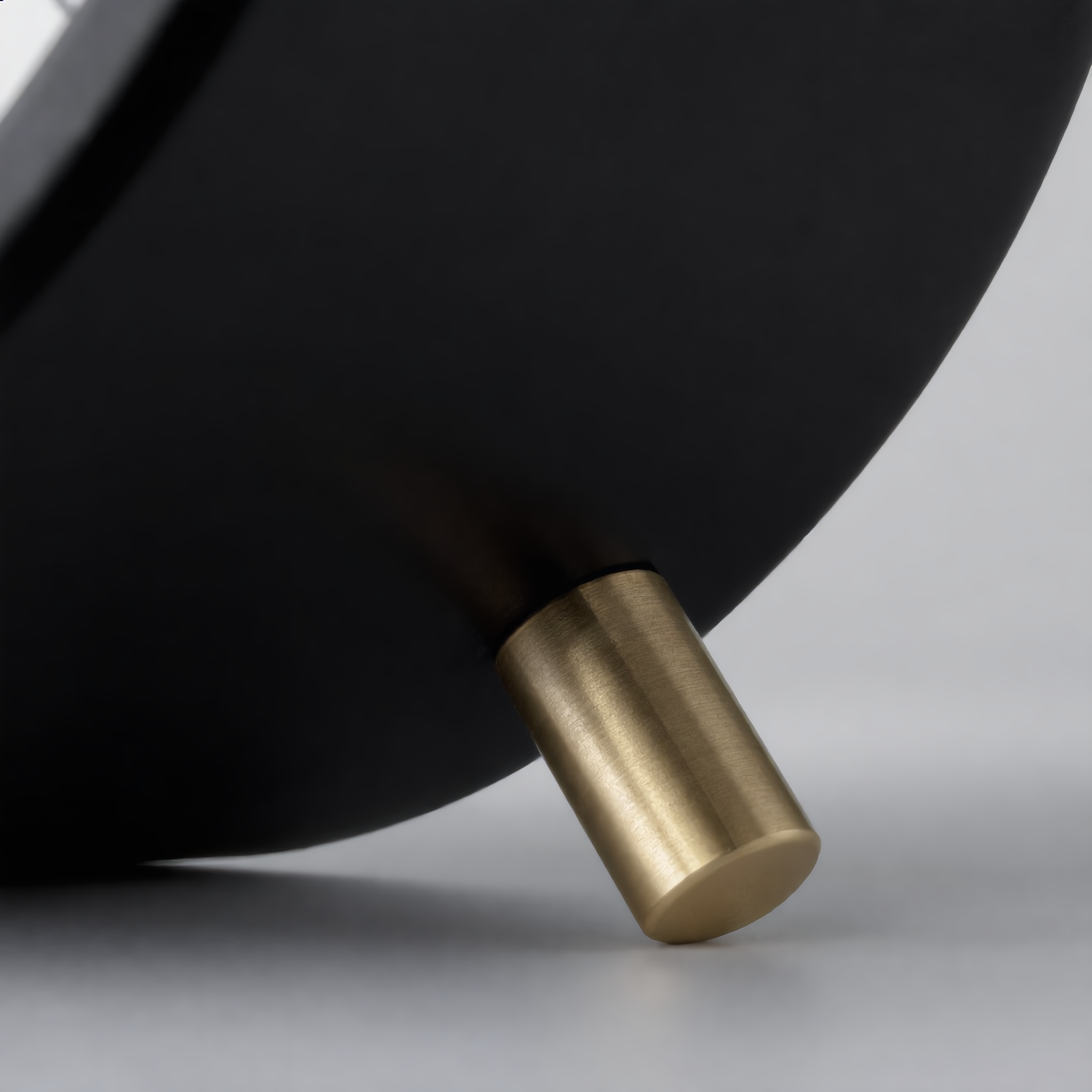 Close-up of the Serena clock brushed-brass feet and case