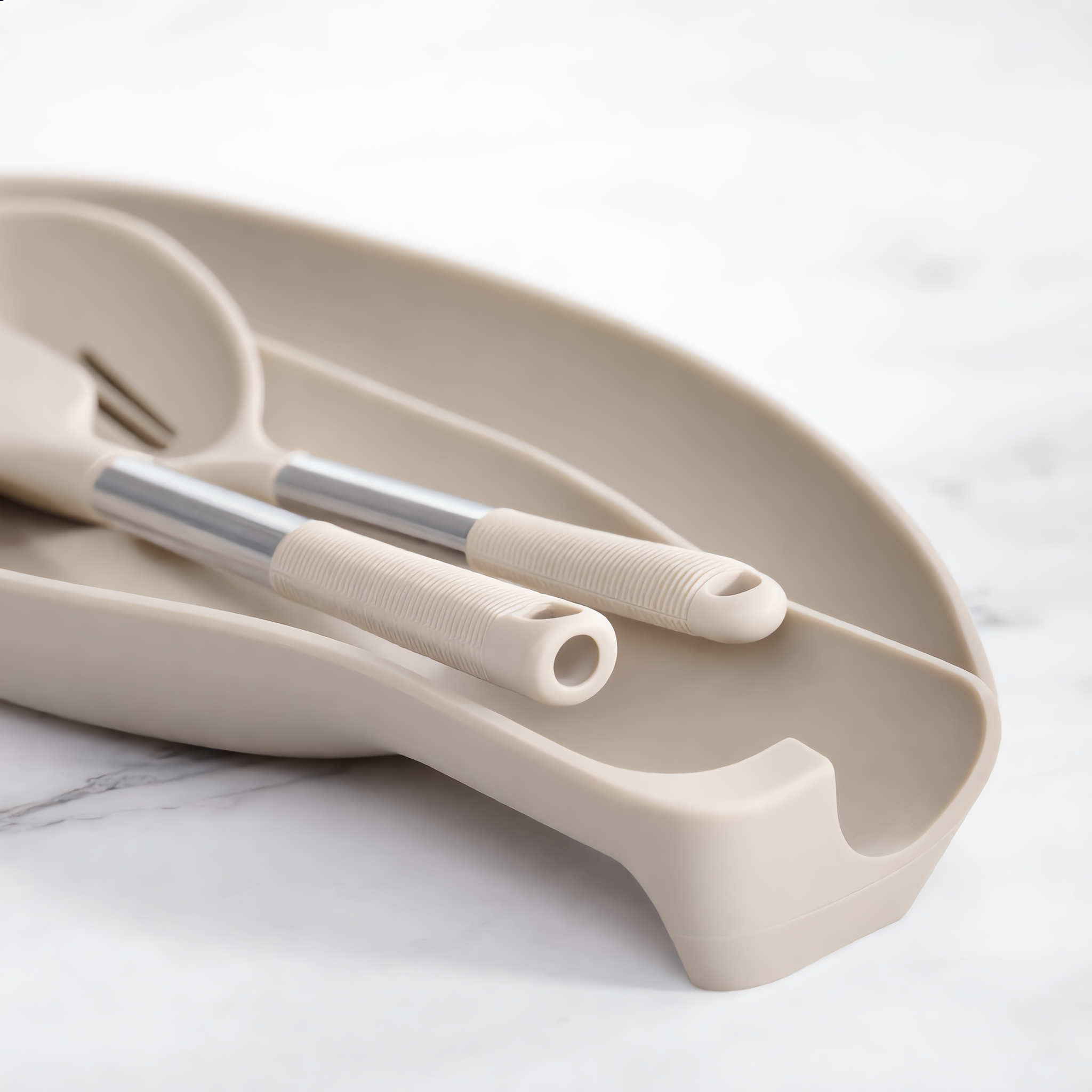 Two khaki utensils resting on the matching silicone utensil rest tray