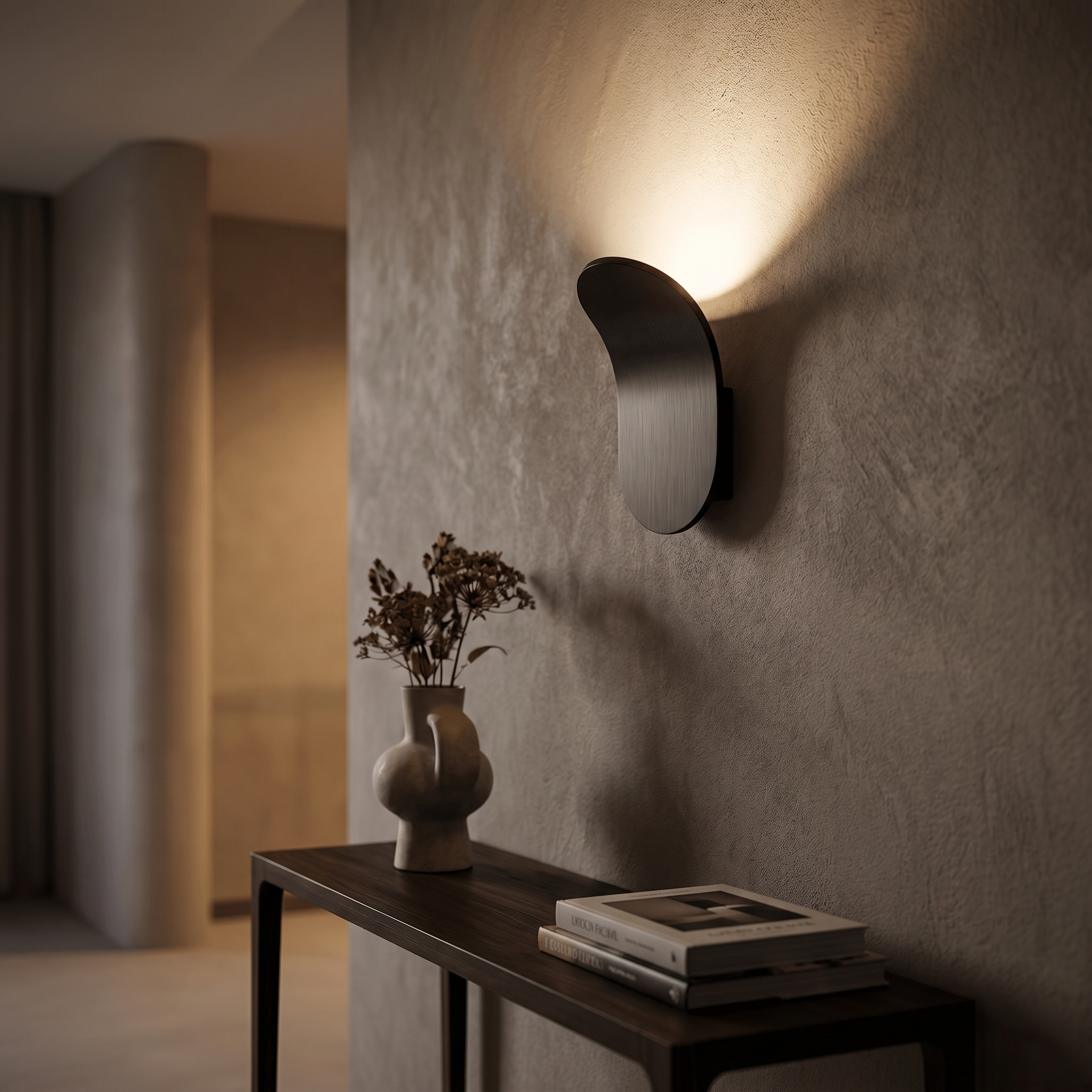 Black curved wall sconce in hallway, warm glow