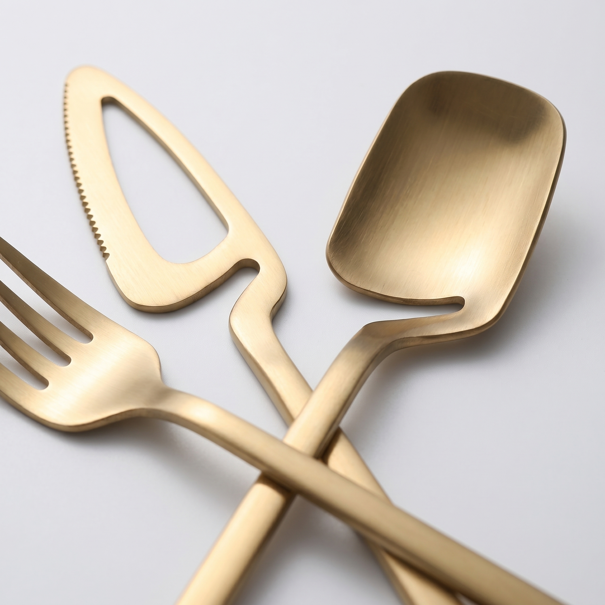 Macro detail of gold sculptural skeleton flatware open teardrop neck and scoop