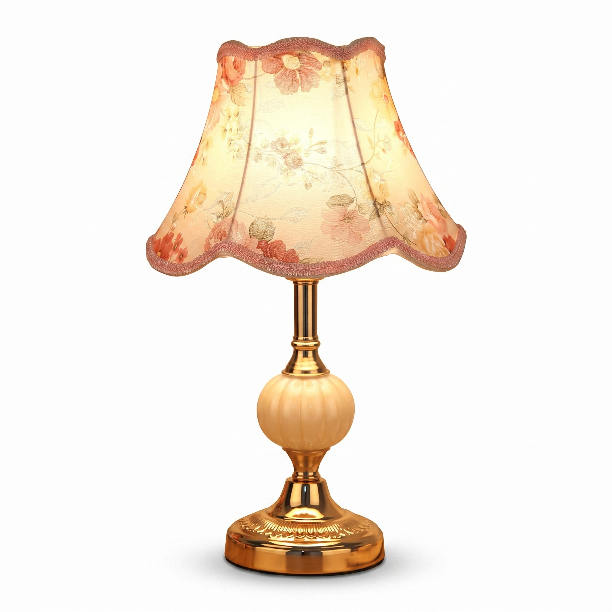Vintage table lamp with gold base and pink floral shade on white background