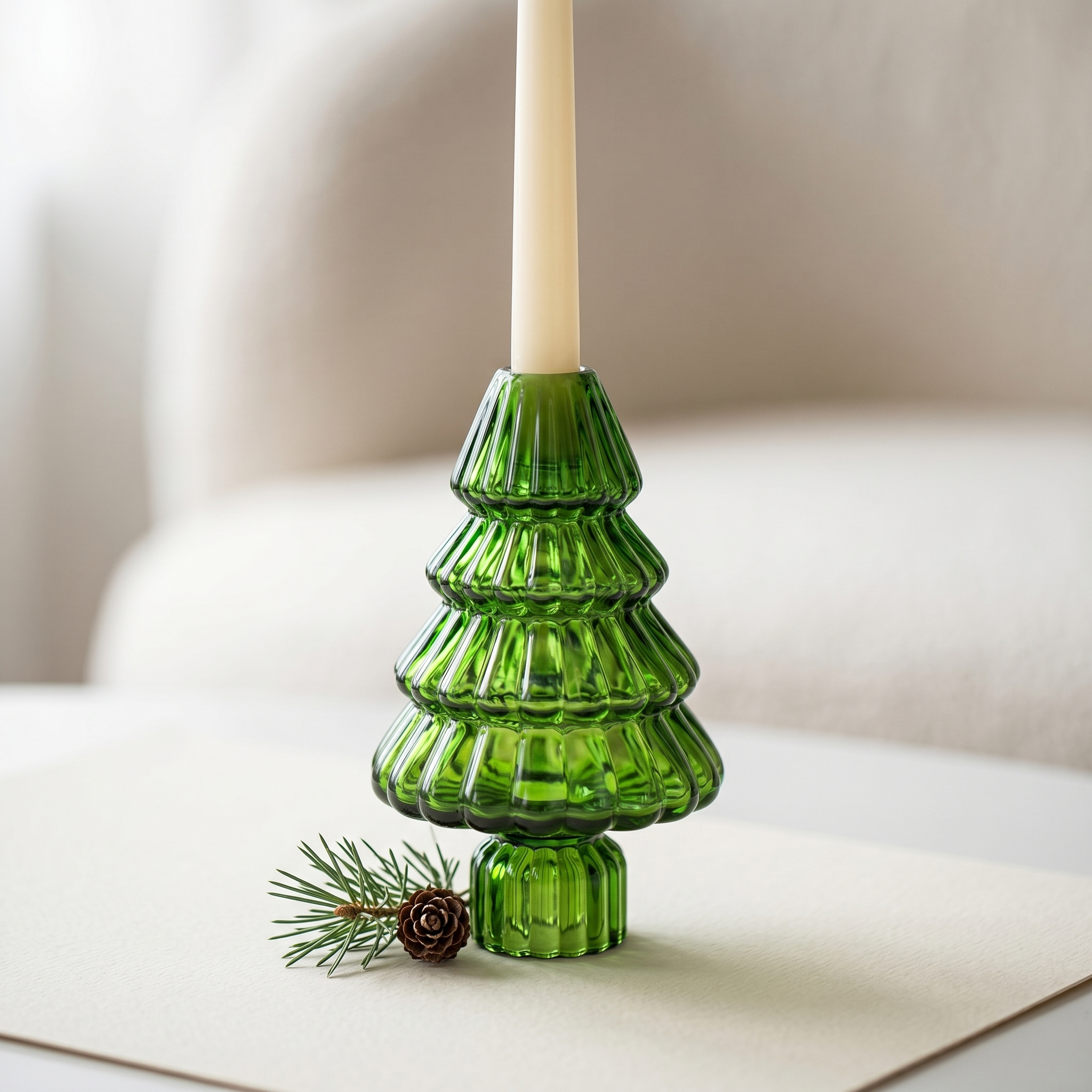 Close-up of an emerald green ribbed glass tree candle holder with a cream taper