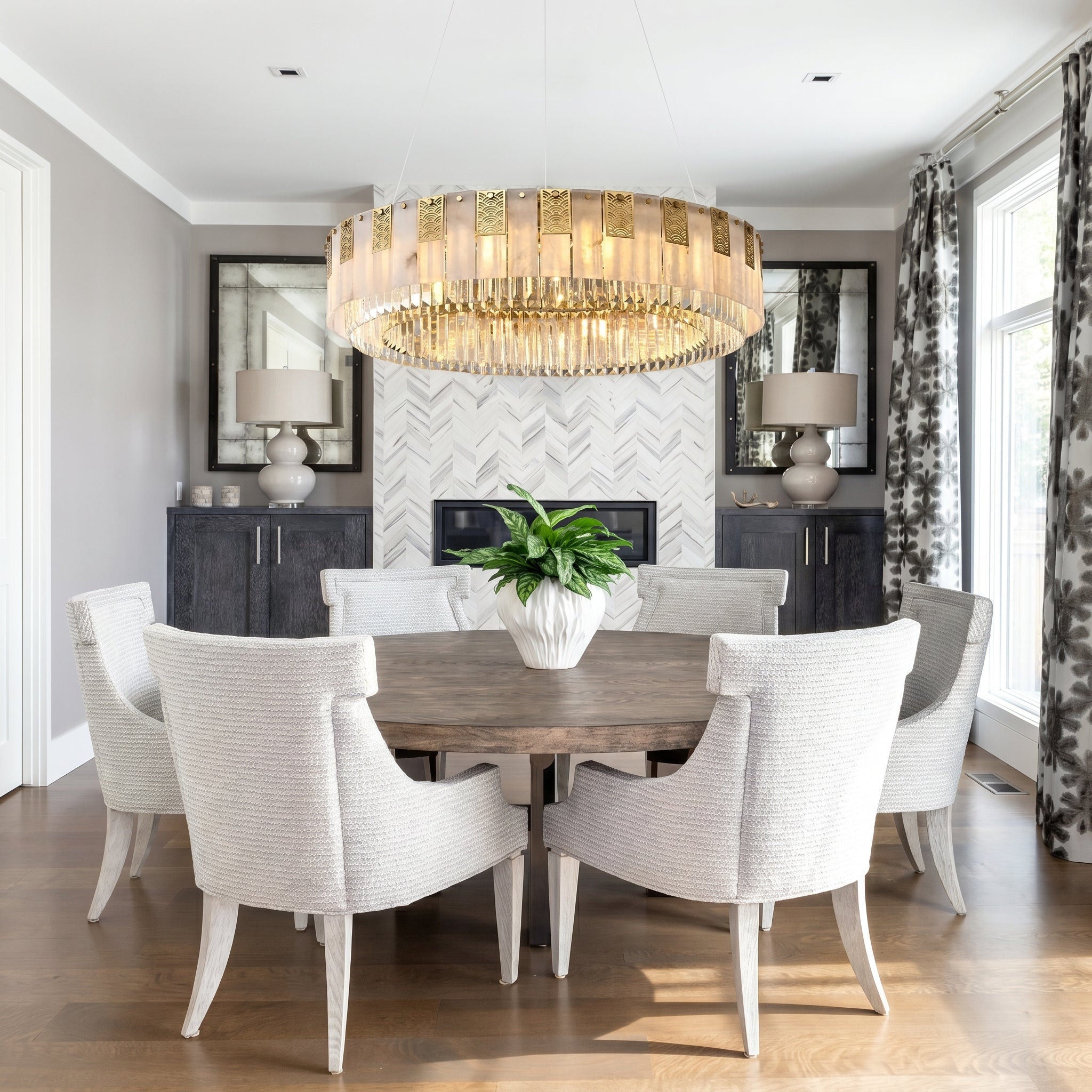 Cascata Brillante round gold crystal pendant over a round table in a modern dining room