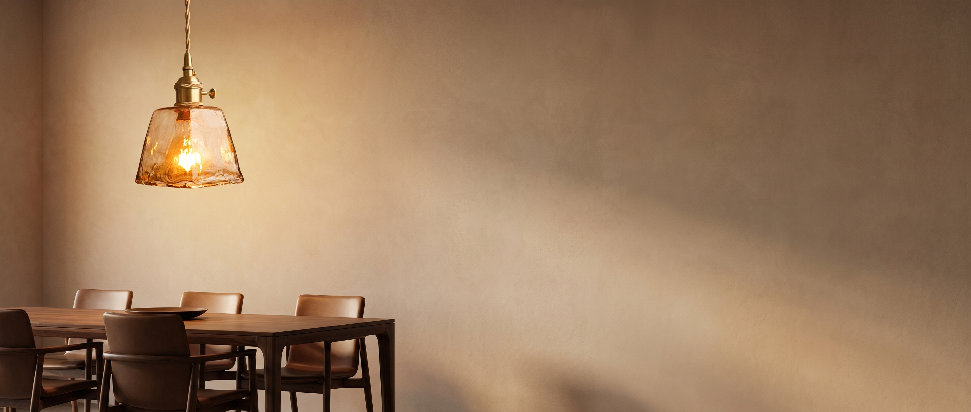 Amber glass pendant light glowing in a modern dining space