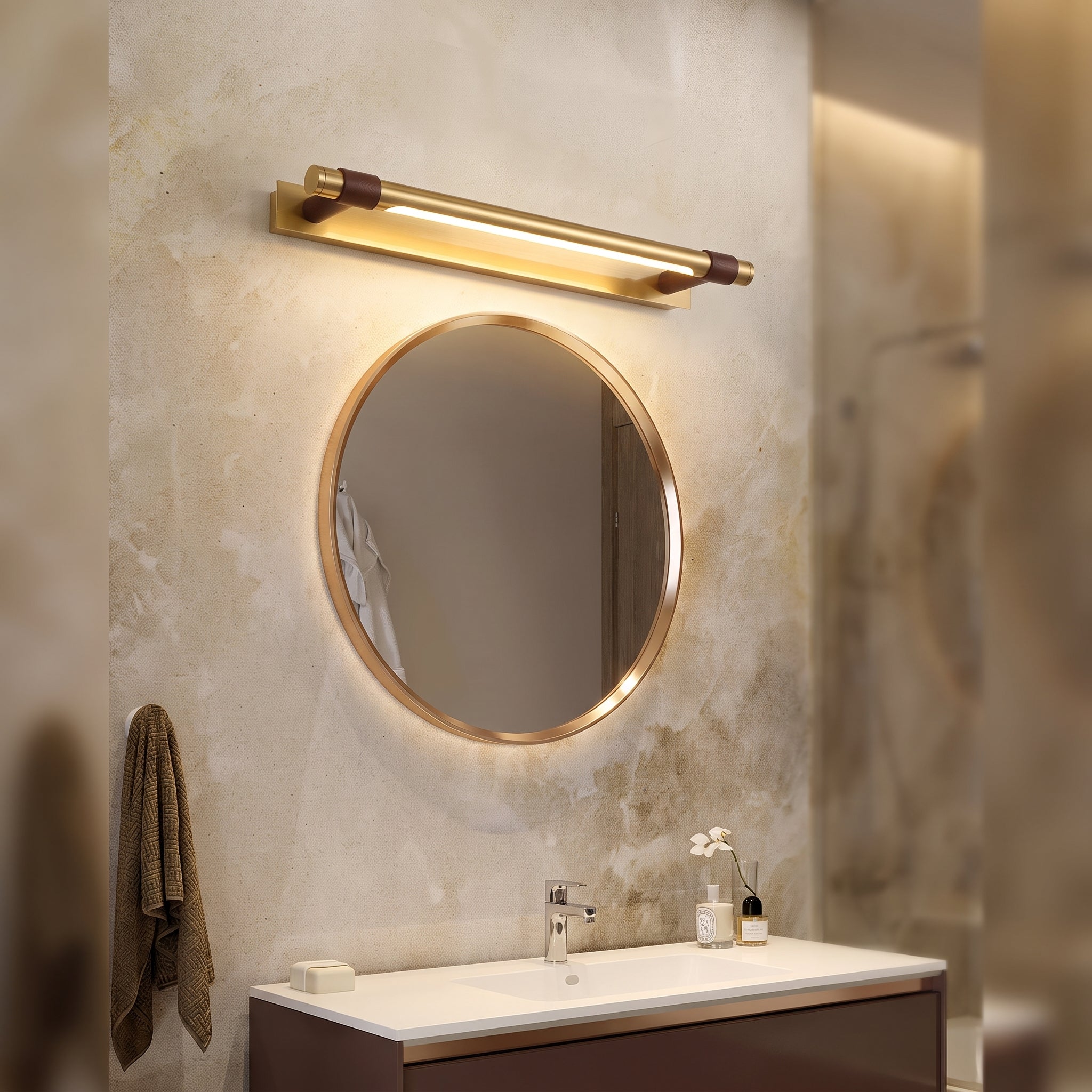 Brass vanity light above round mirror