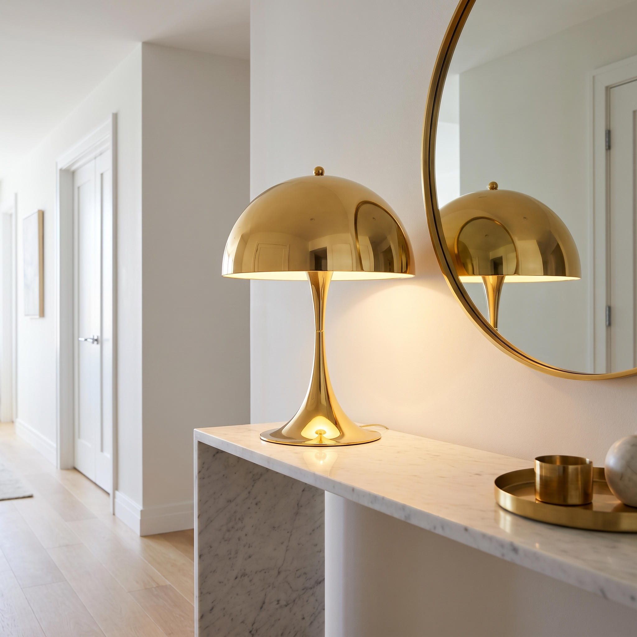 Gold mushroom table lamp on an entryway console with a round mirror