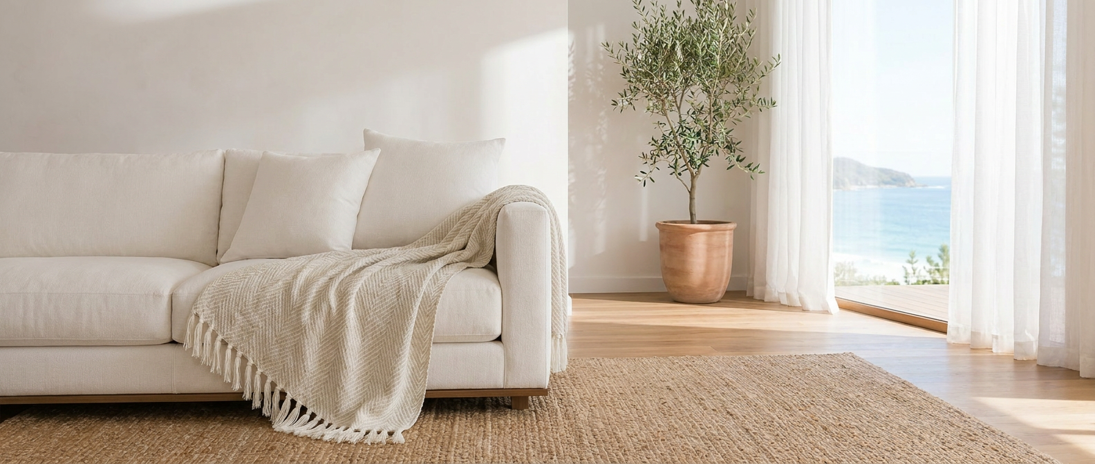 Beige Brezza Marina woven throw draped over a sofa in a bright airy coastal living room
