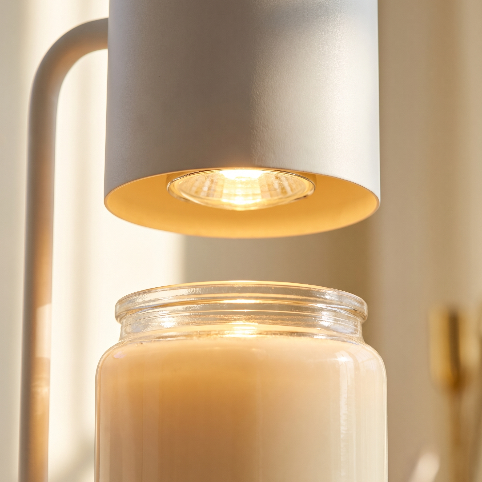 Close-up of the candle warmer lamp head glowing over a candle