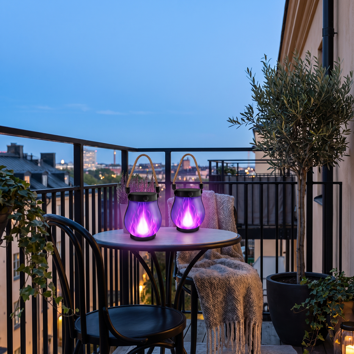 Purple flame solar lanterns on a bistro table on a city balcony at blue hour