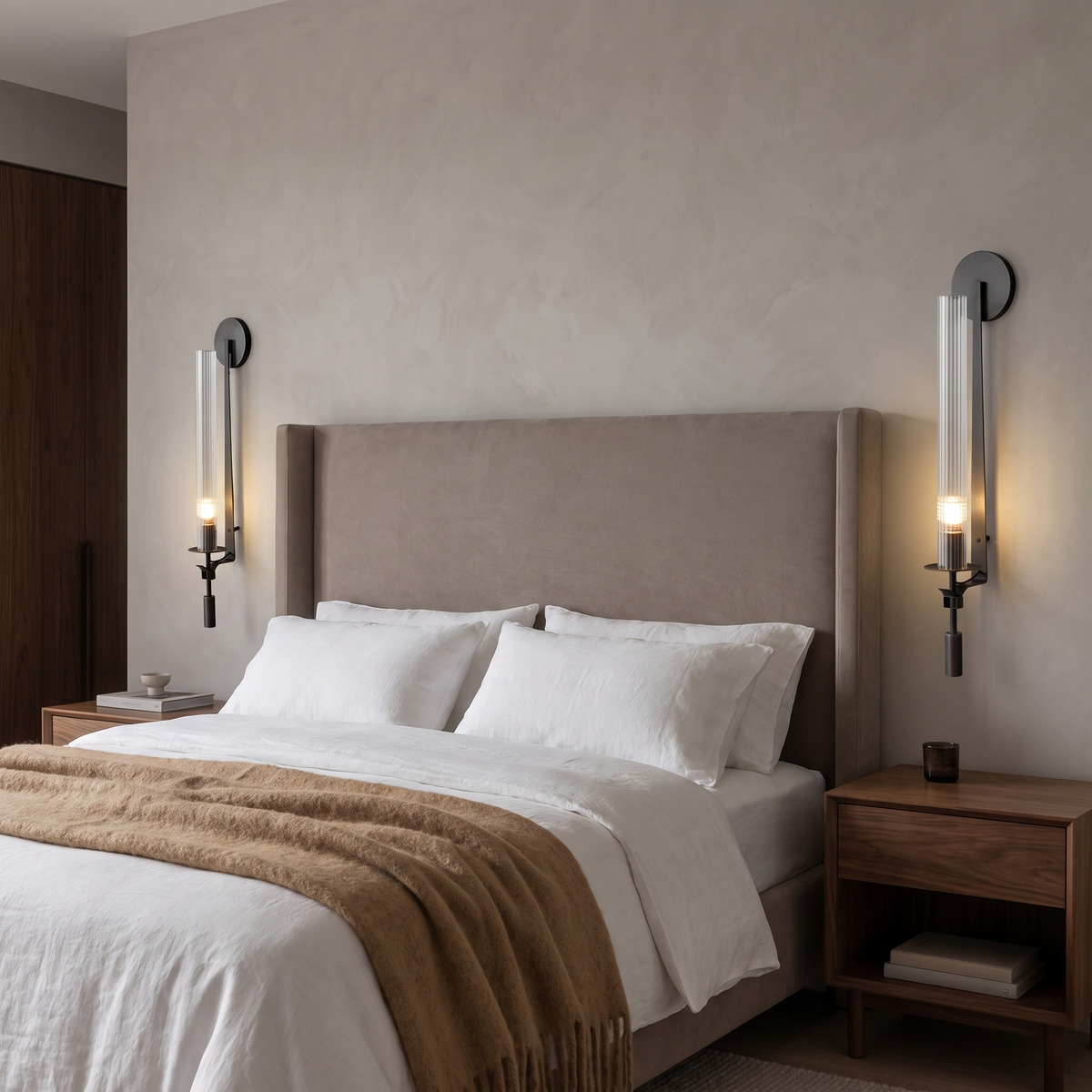 Pair of black ribbed glass wall sconces beside an upholstered bed