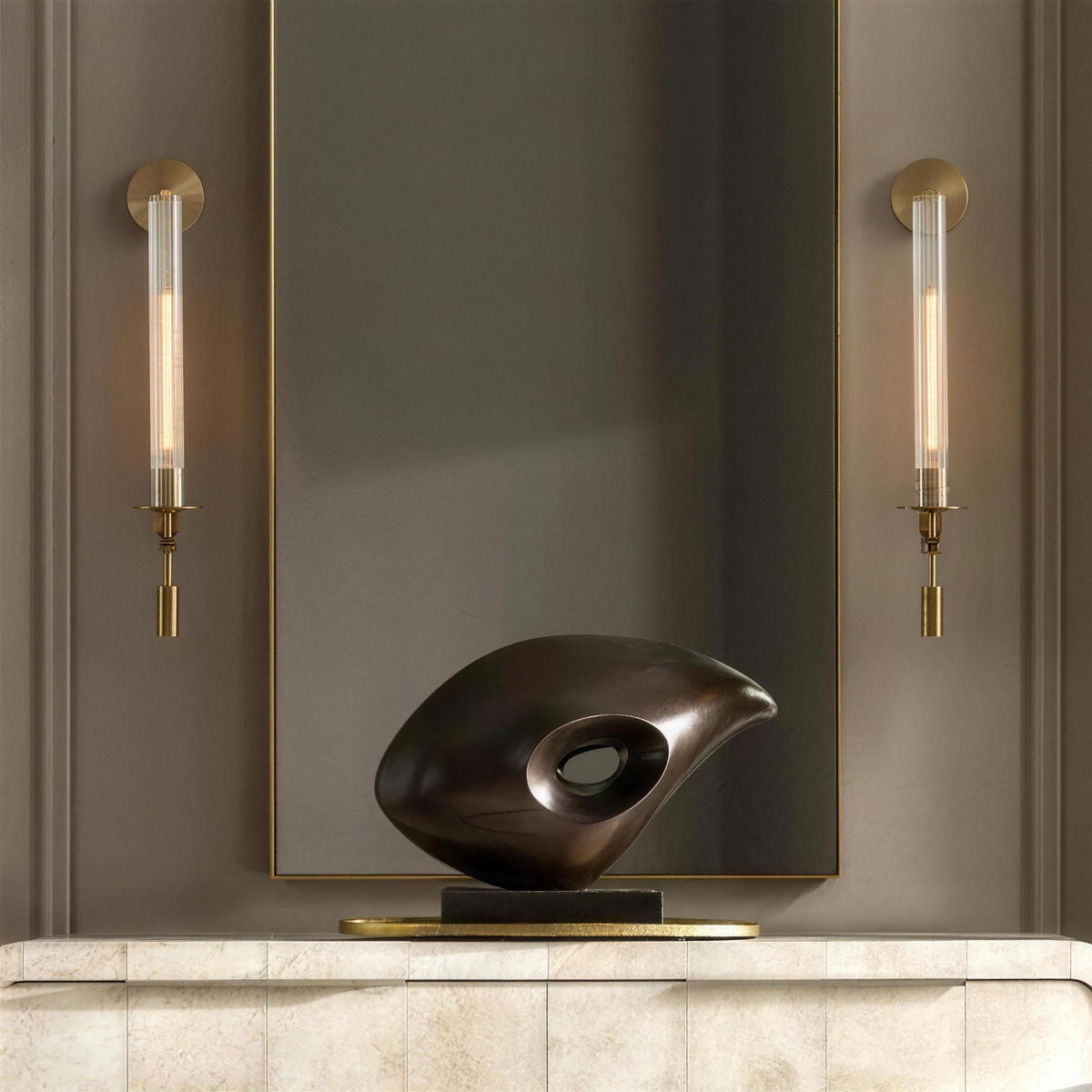 Pair of gold ribbed glass wall sconces flanking a mirror with a bronze sculpture