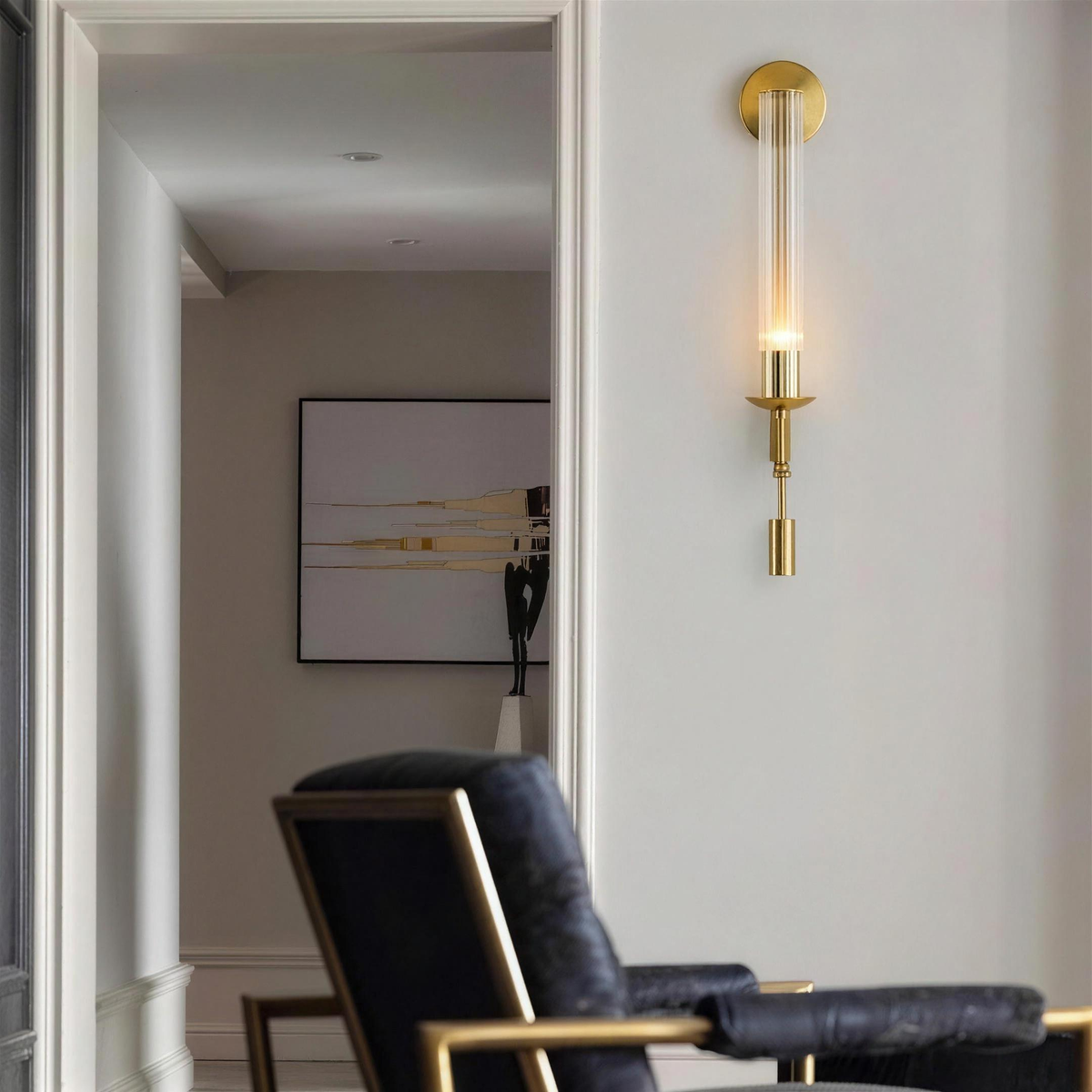 Gold ribbed glass wall sconce in a hallway beside a lounge chair