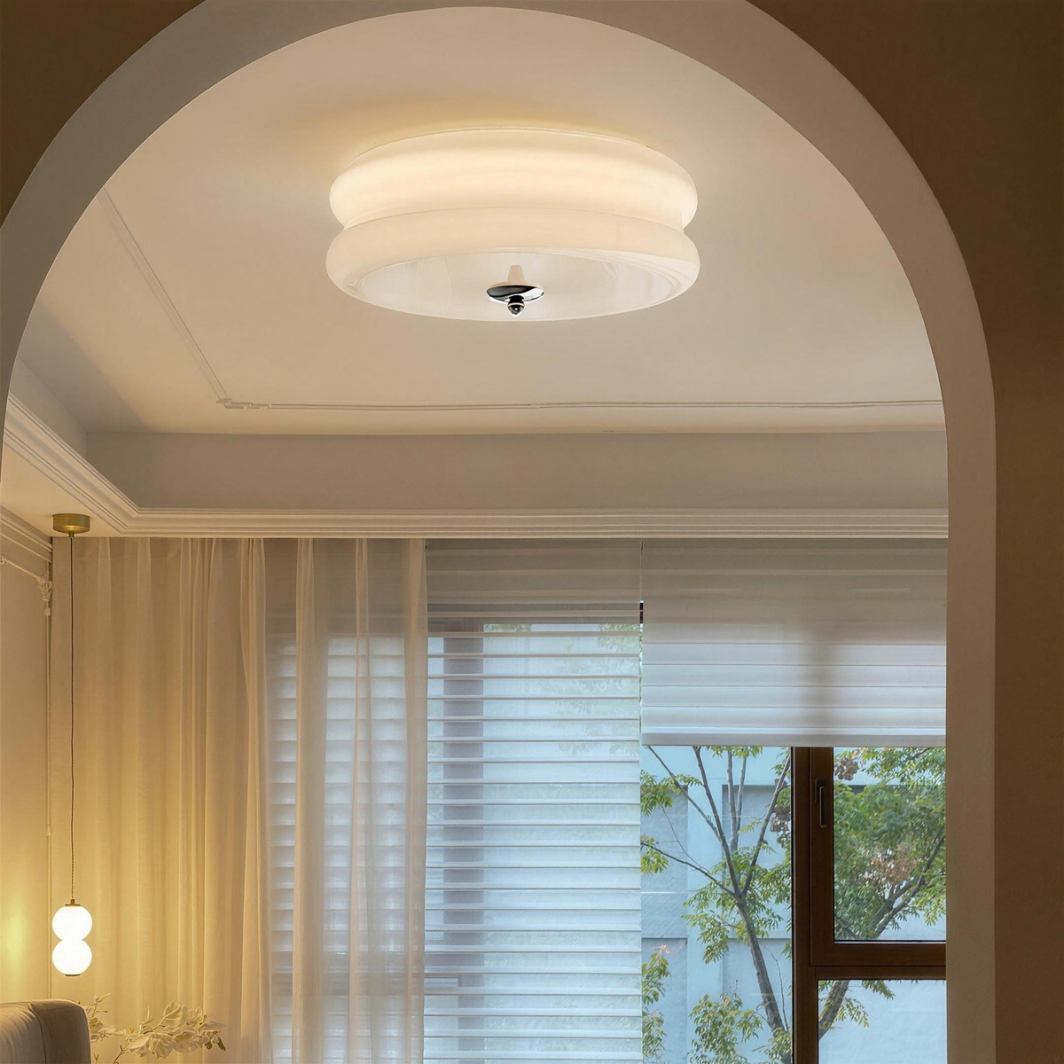 Ribbed glass ceiling light glowing in a room with an arched window