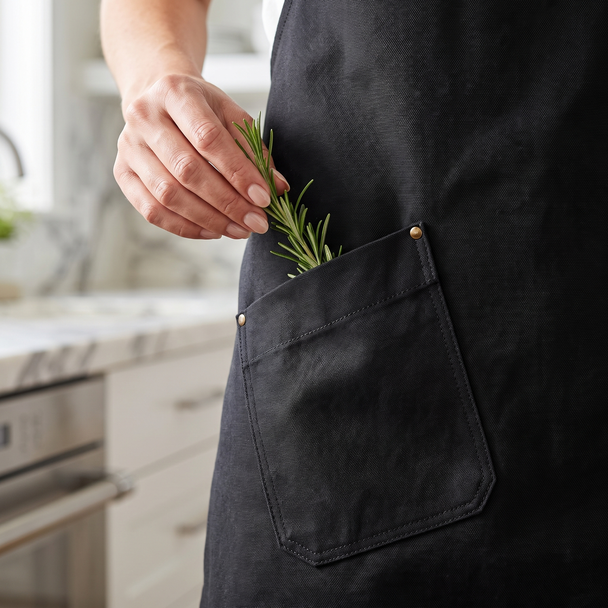 Close-up of the angled hip pocket with brass rivet on the black apron