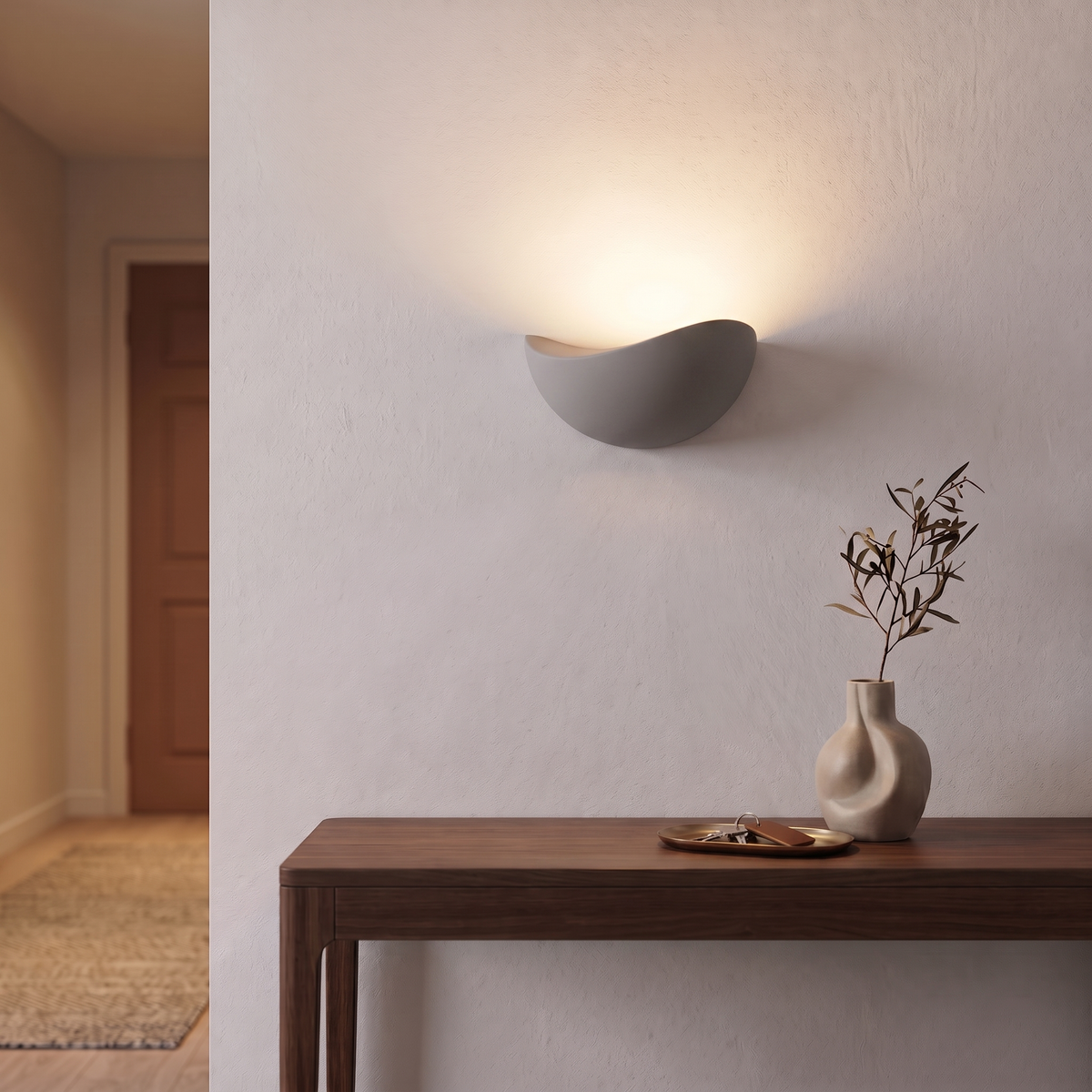 White Mezzaluna sconce washing the hallway wall above a console with upward light
