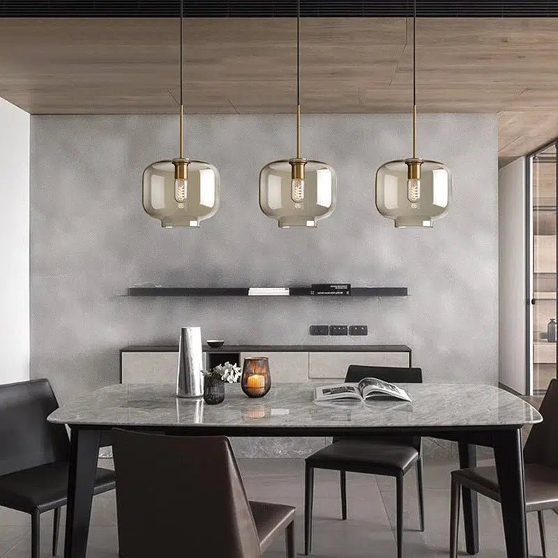 Ambra cognac glass pendants over a marble dining table