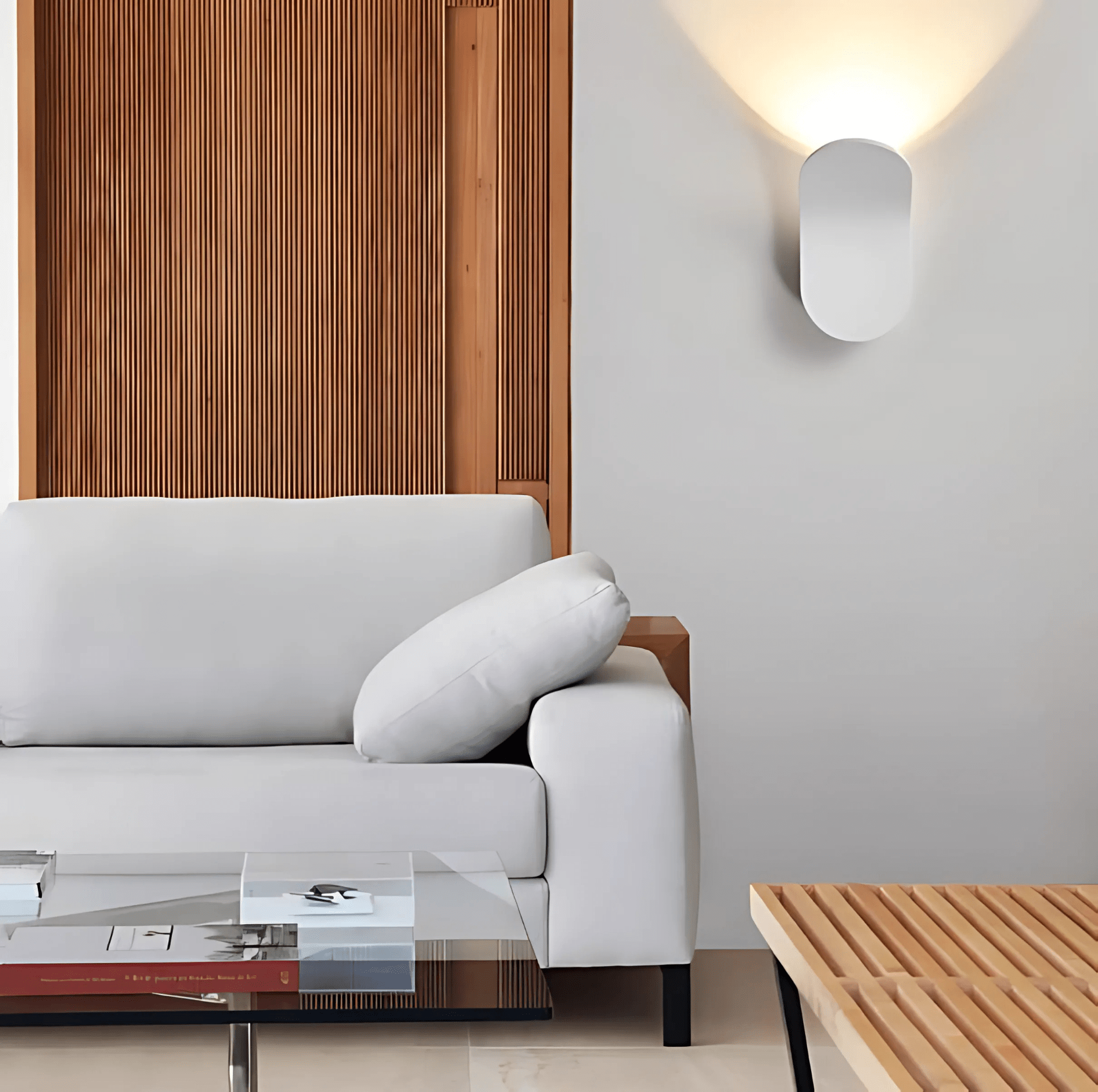 White curved wall sconce in a living room beside a sofa