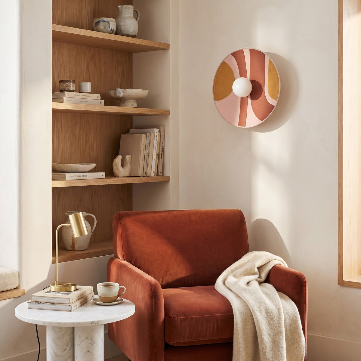 Luna Tessuta wall sconce in Rose Stripe above a rust velvet chair in a reading nook