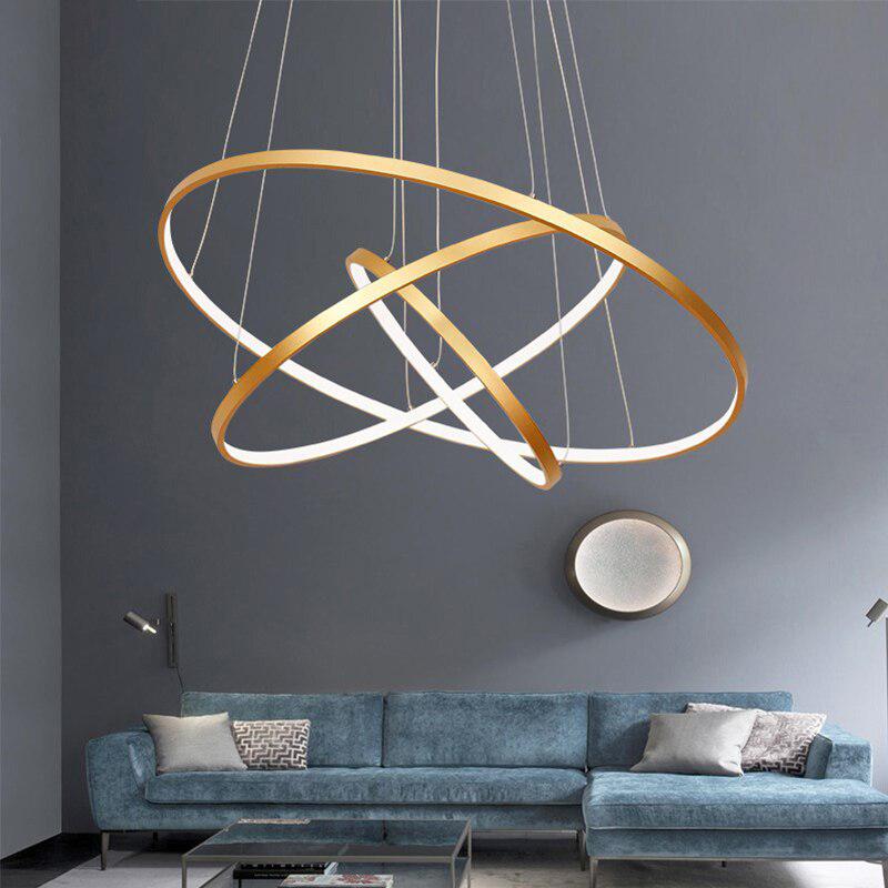 Gold LED ring chandelier above a blue sofa in a living room