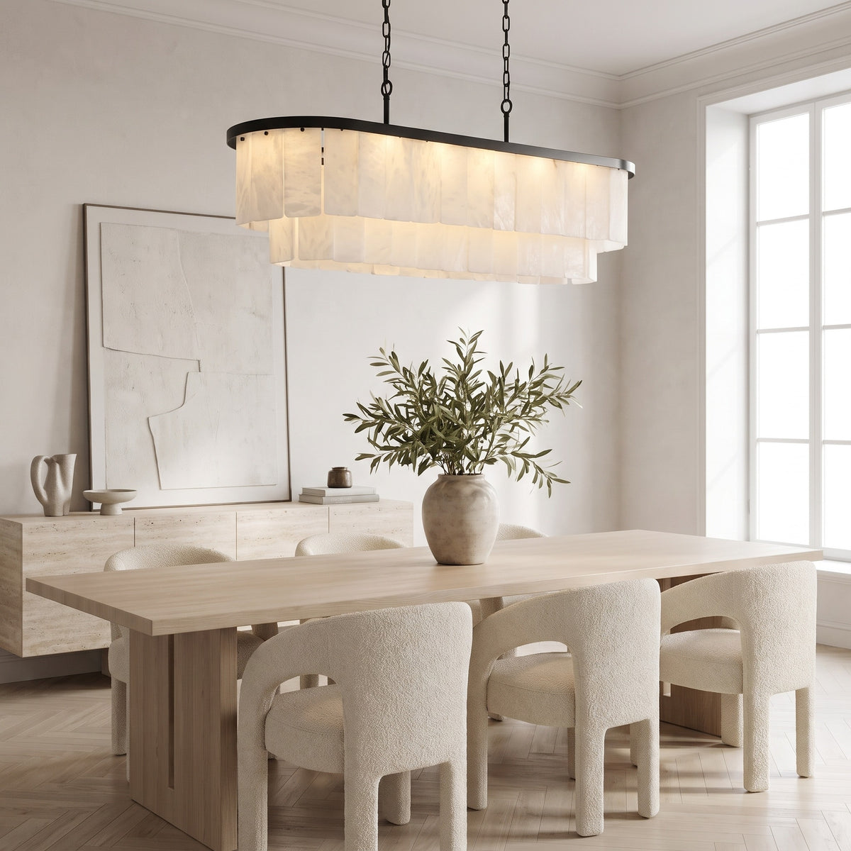 Velo Alabastro tiered alabaster linear chandelier over a pale oak dining table in a bright modern dining room