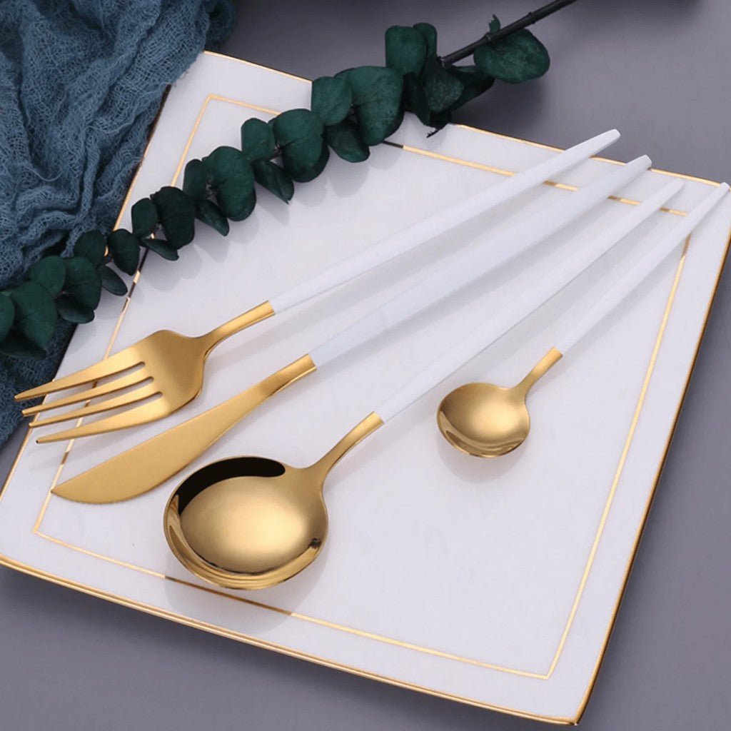 White and gold cutlery with linen napkins and eucalyptus