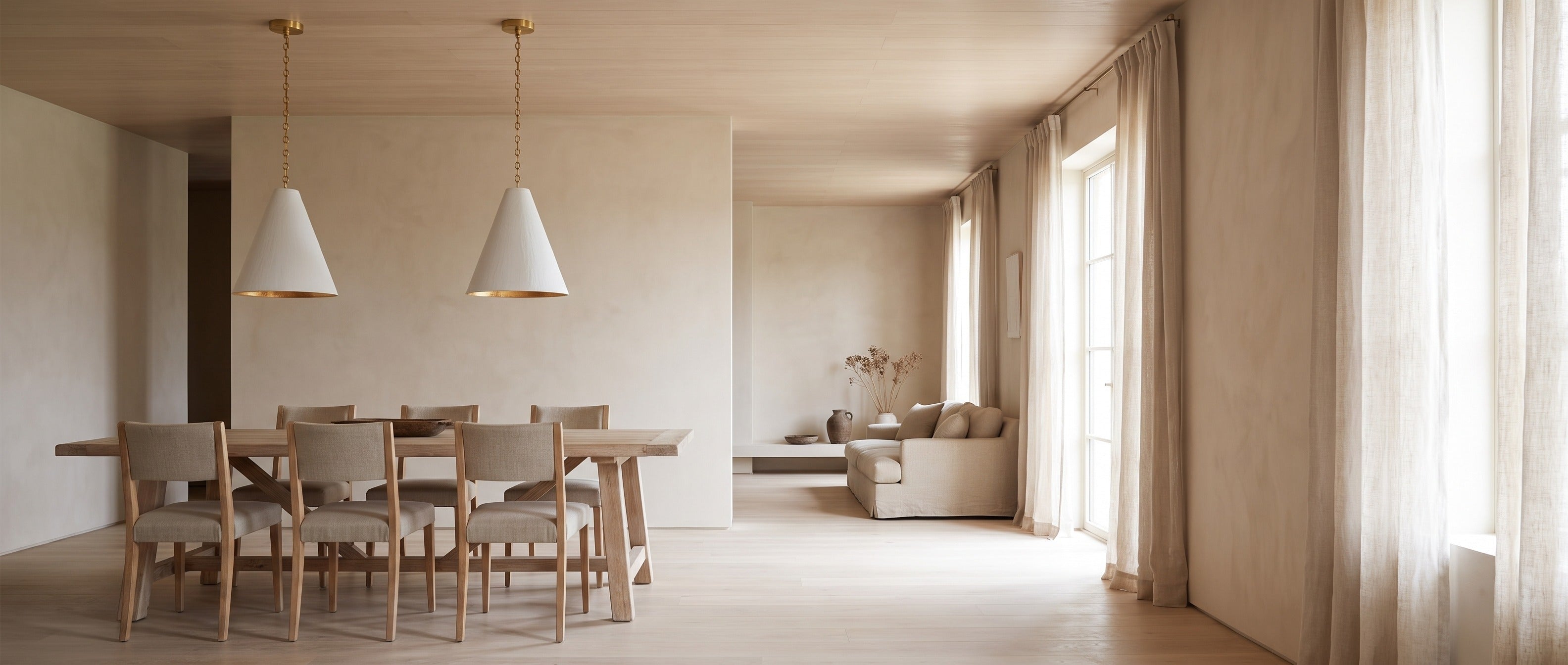 Calma Gessata plaster cone pendants over a dining table in a bright wabi-sabi home