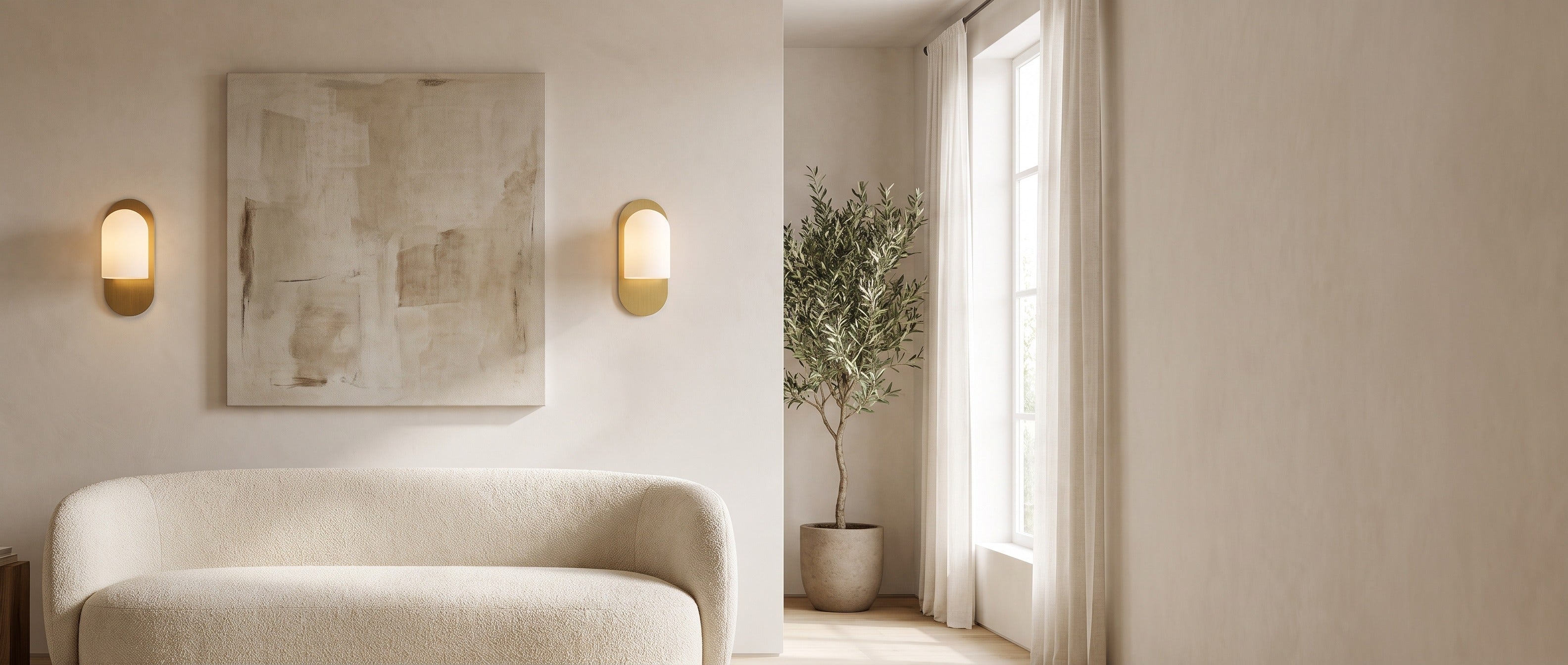Pair of Capsula Opalina brass wall sconces flanking artwork above a boucle sofa