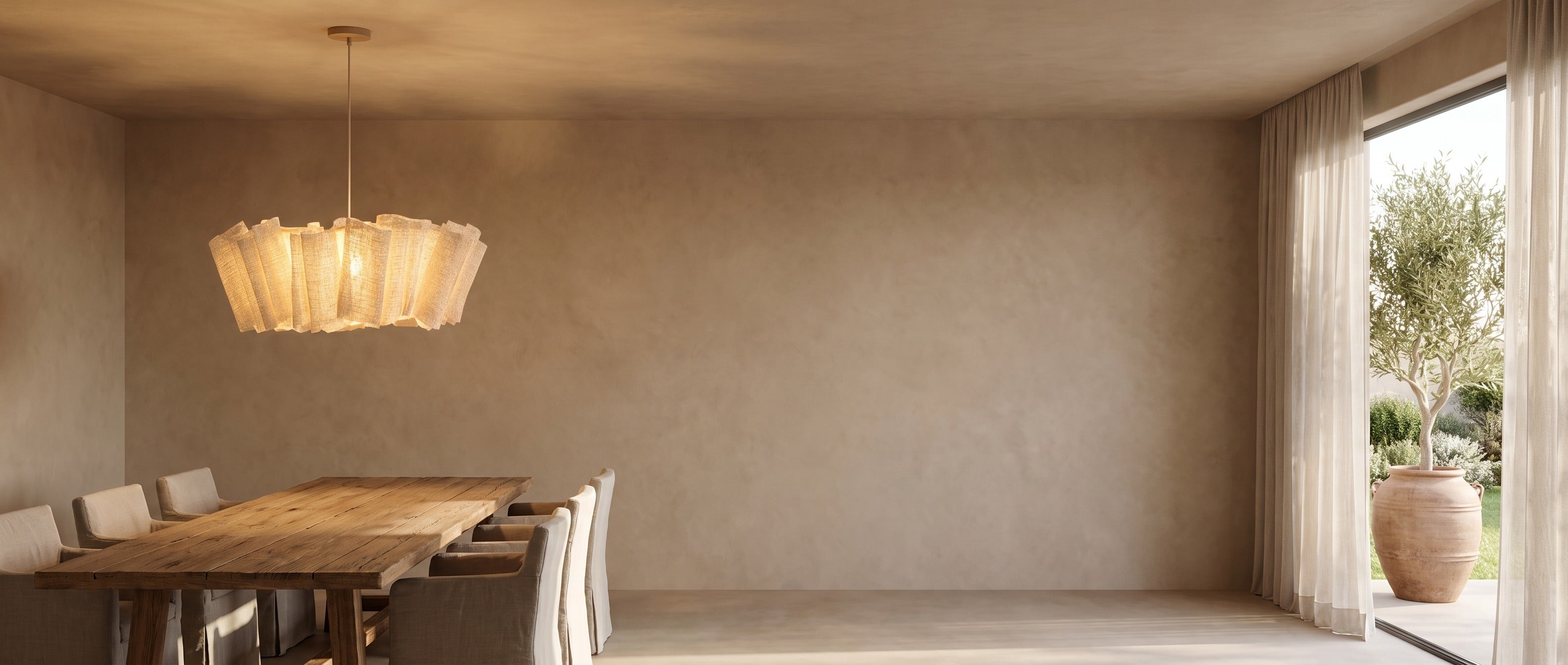 Woven abaca pendant above a rustic oak dining table in a wabi-sabi room