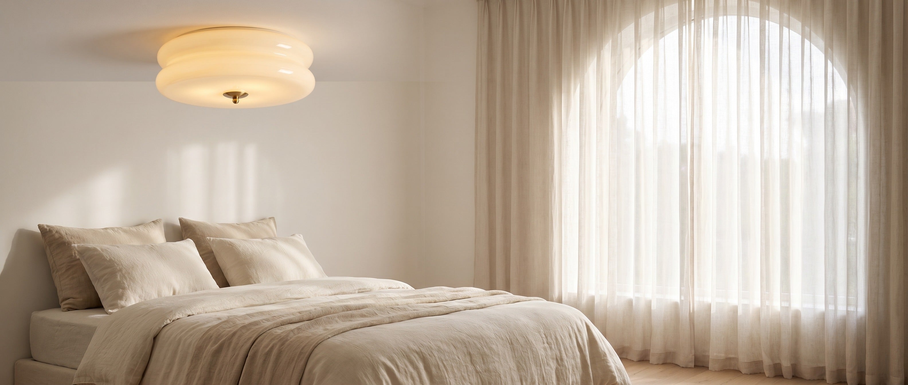 Beige ribbed glass ceiling light in a serene bedroom with an arched window